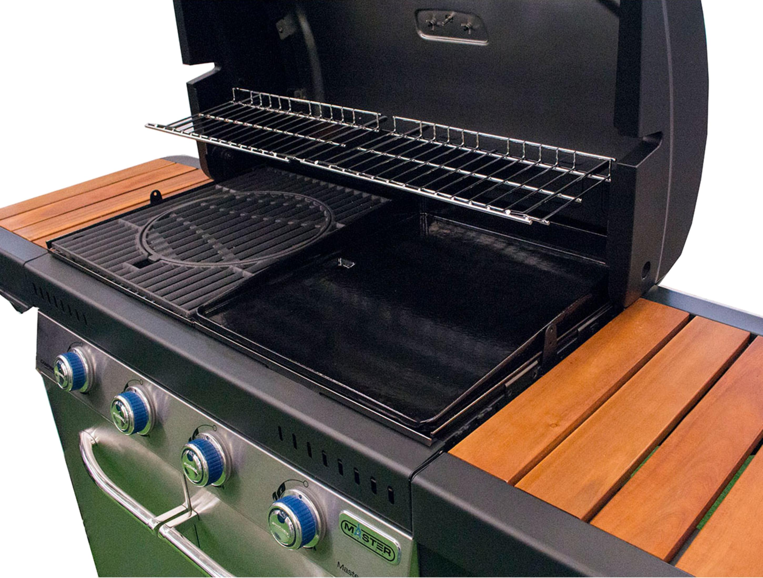 Ein offener Grill mit Metallrosten, einer Grillplatte und hölzernen Seitentischen.