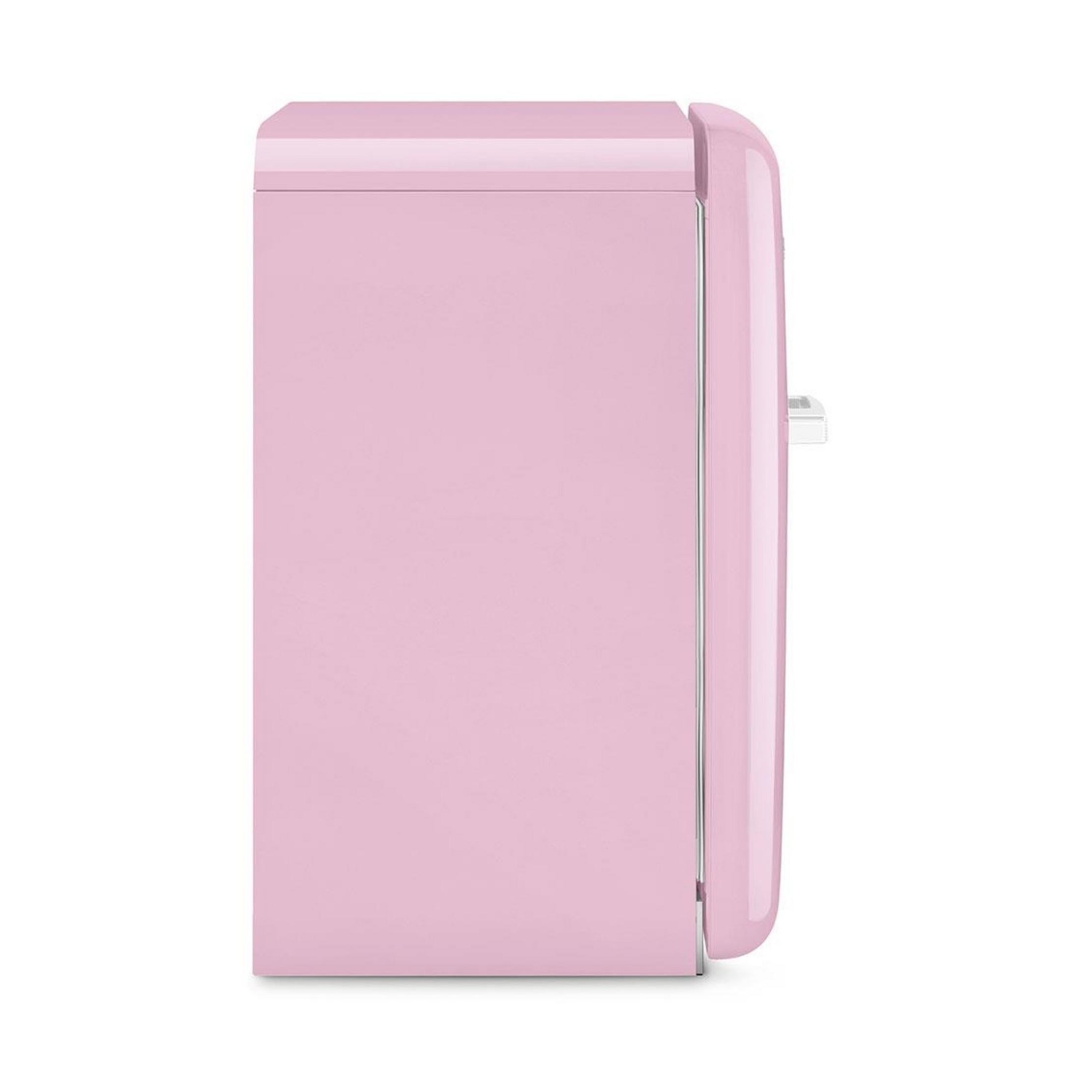 Un refrigerador rosa con asa plateada, visto de lado.