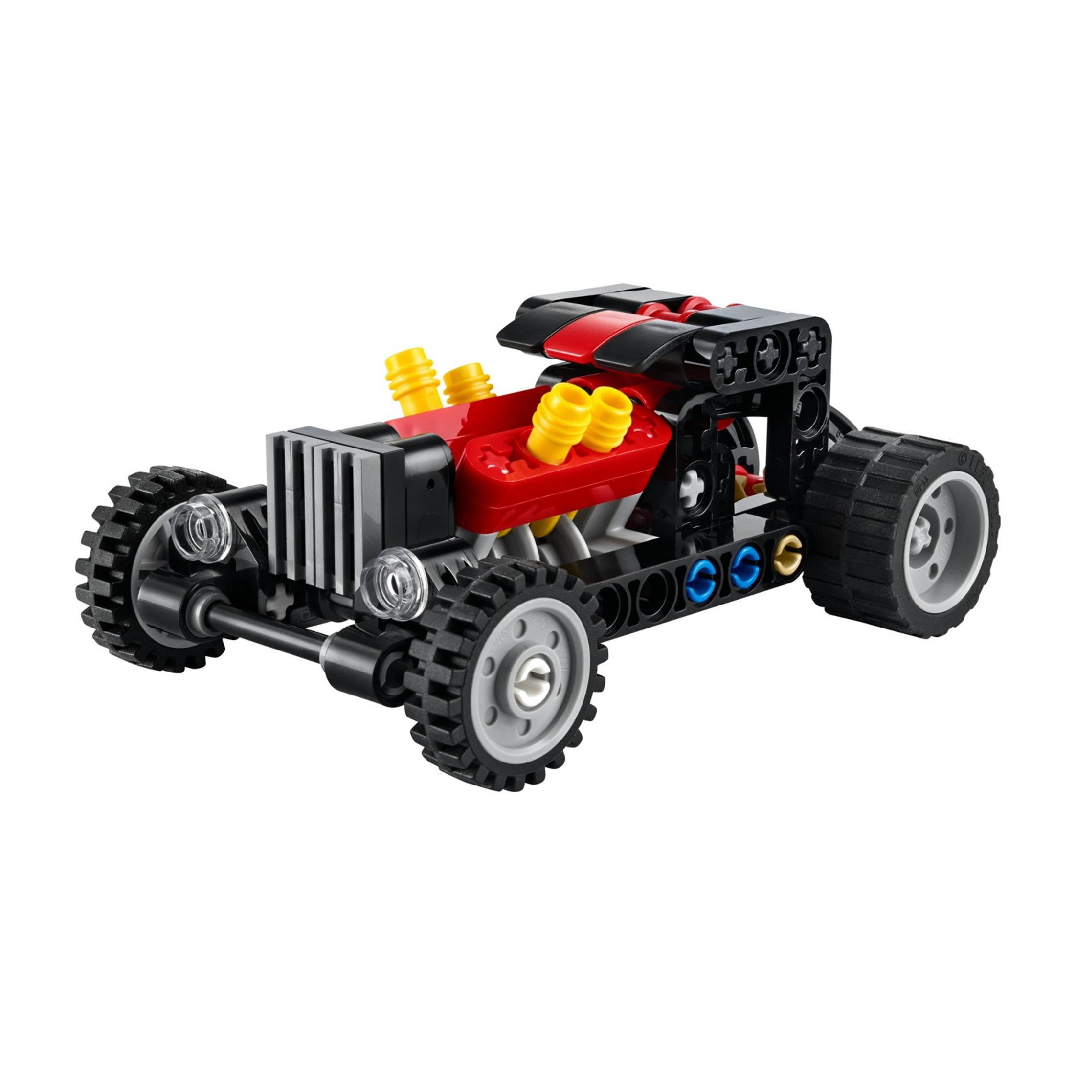Sarı egzoz boruları ve büyük tekerlekleri olan kırmızı ve siyah Lego yarış arabası.