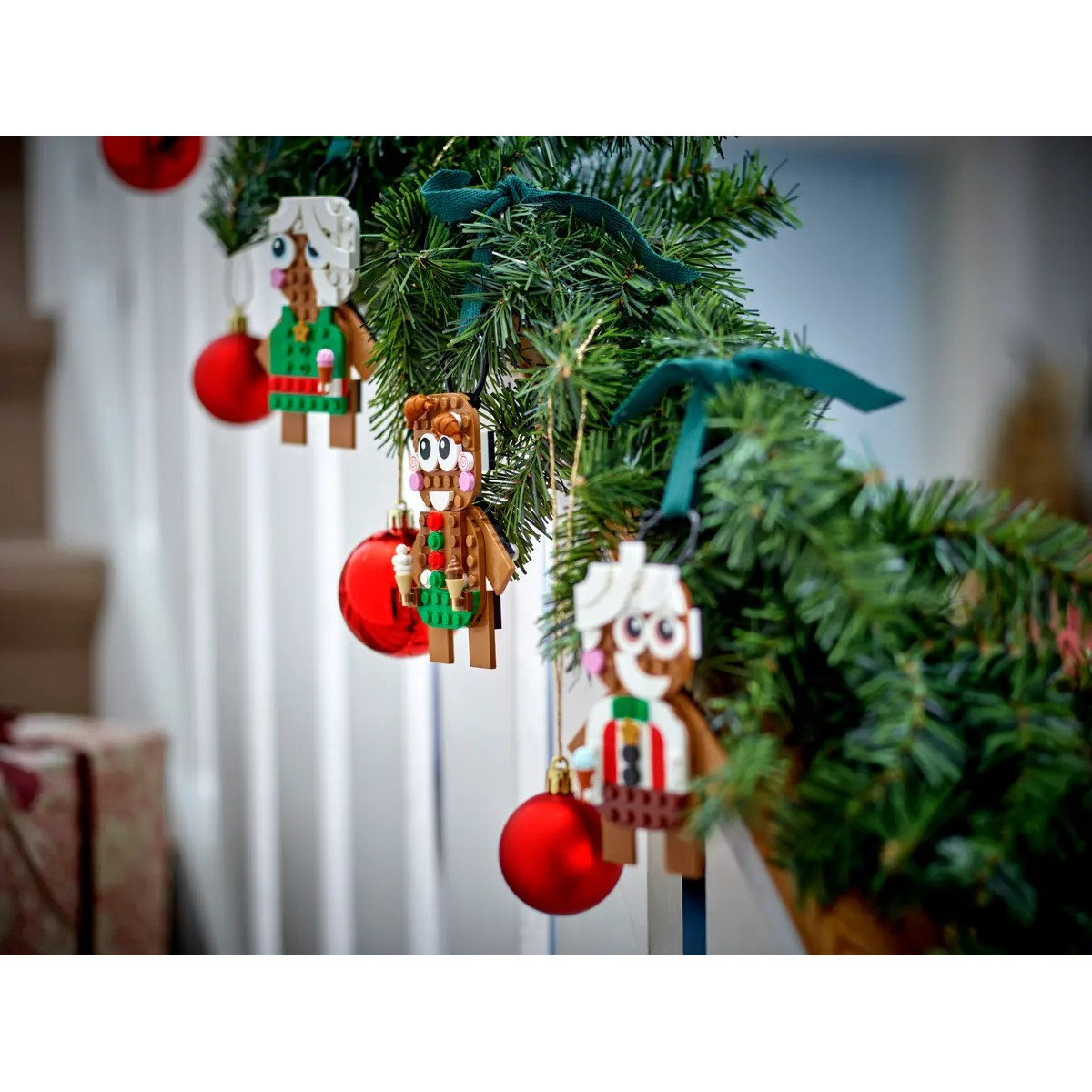 Lego-Figuren als Weihnachtsbaumschmuck mit roten Kugeln und Tannengrün.