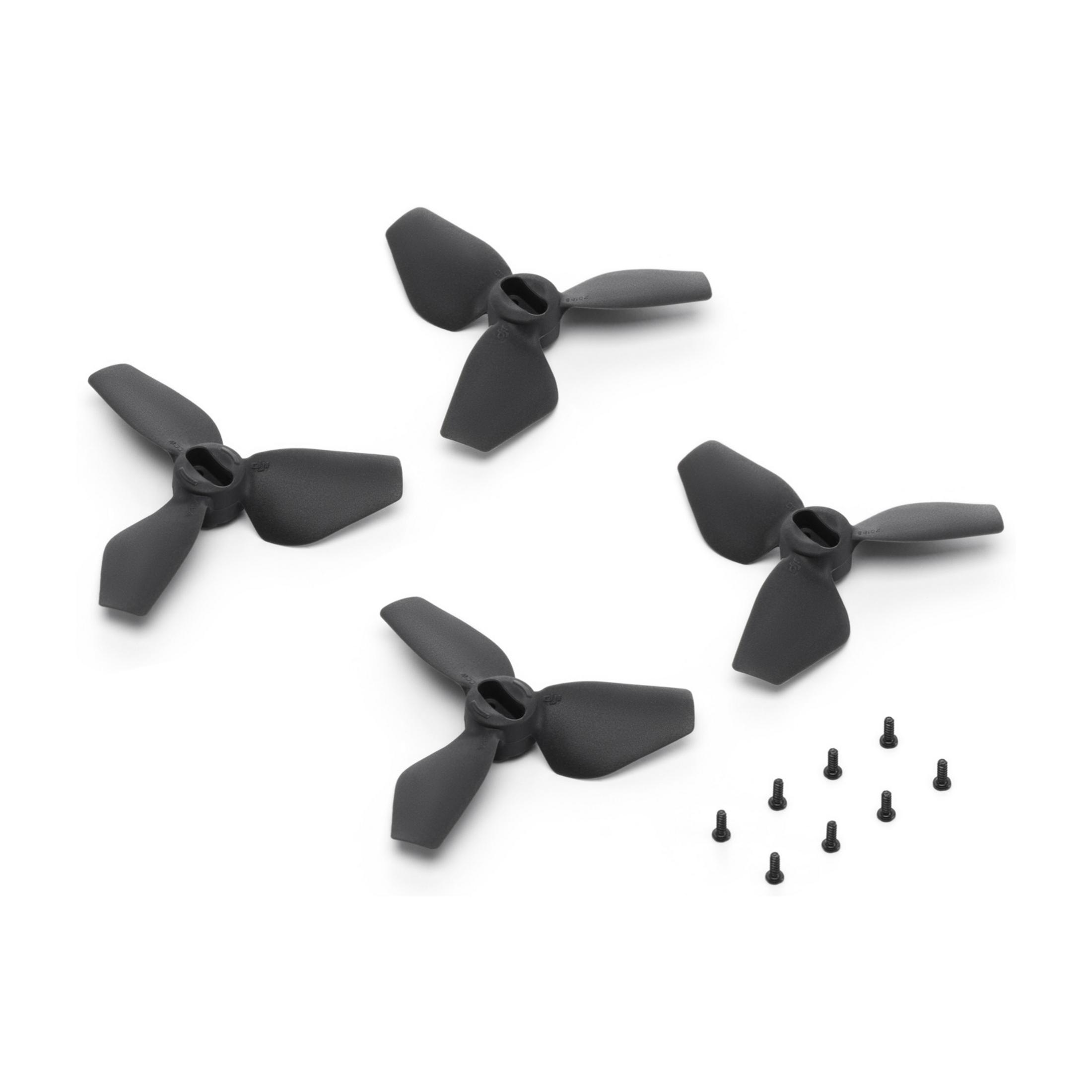 Cuatro hélices negras para drones y ocho tornillos sobre fondo blanco.