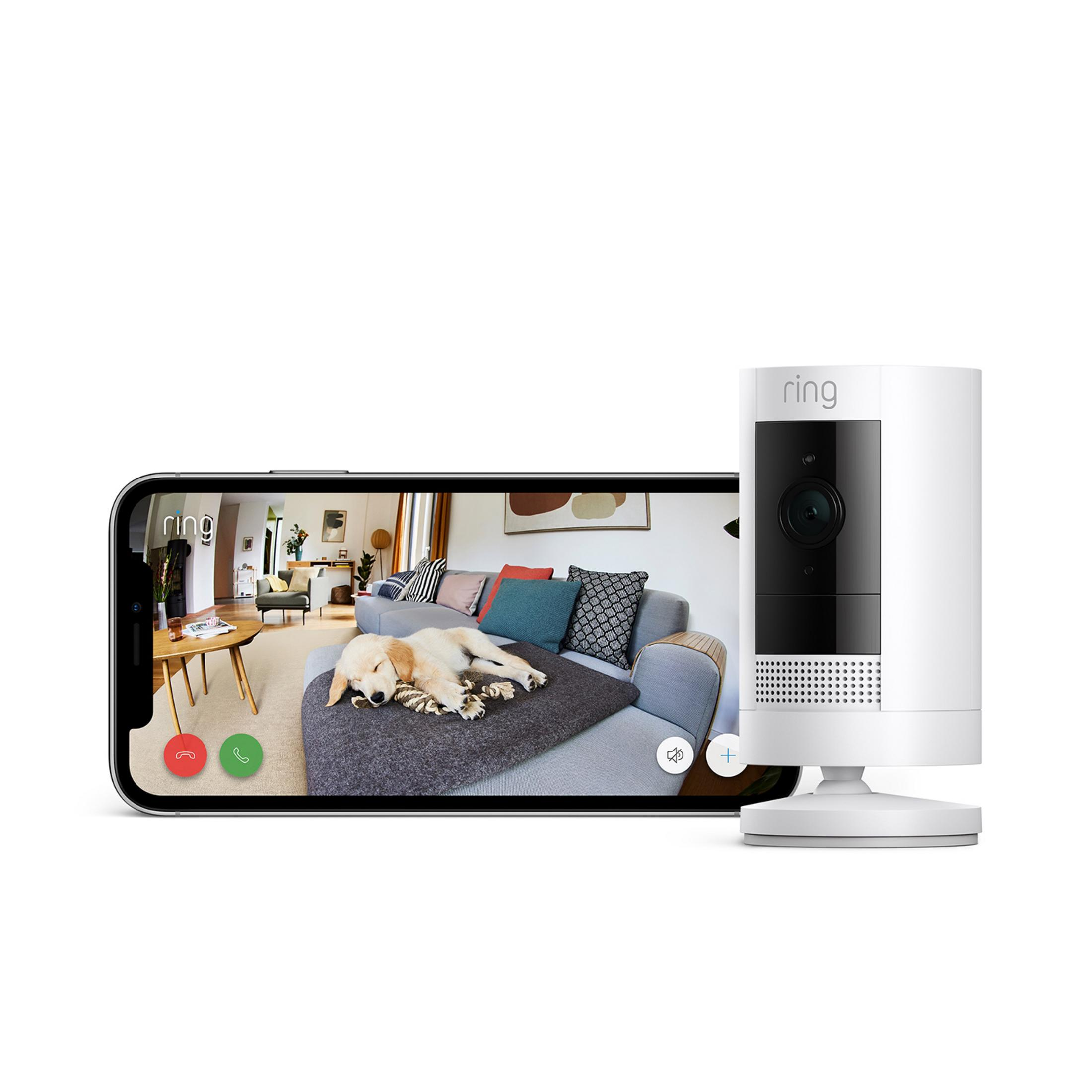 Kamera Ring obok smartfona z psem śpiącym na kanapie.