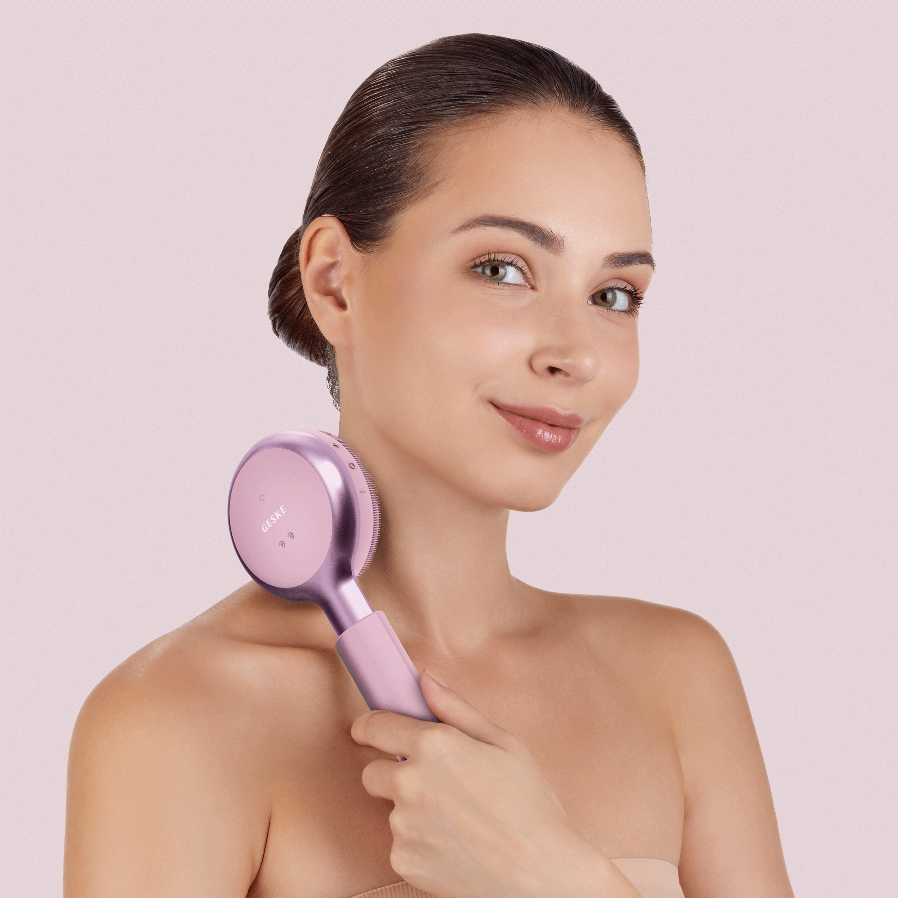 Düz saçlı kadın, boynunun arkasında pembe bir cilt bakım cihazı tutuyor.