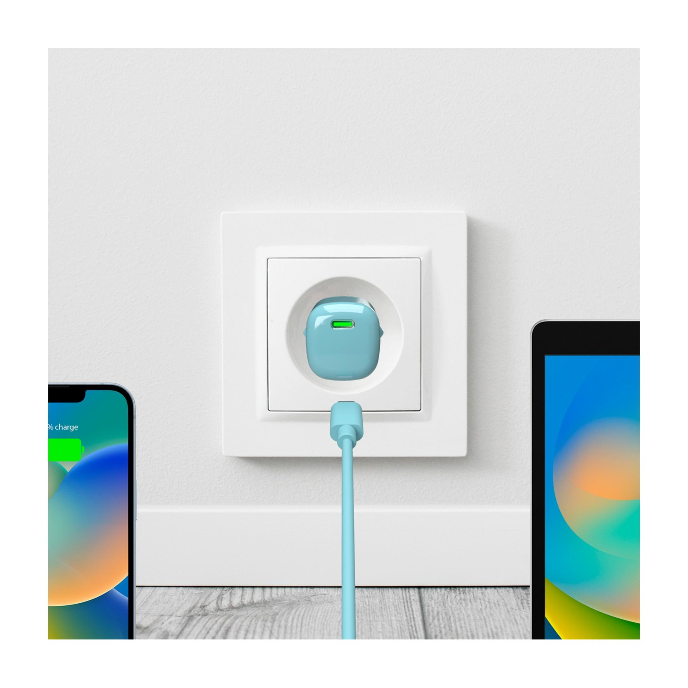 Une prise de charge bleue avec une lumière verte est dans une prise murale blanche à côté de deux smartphones.
