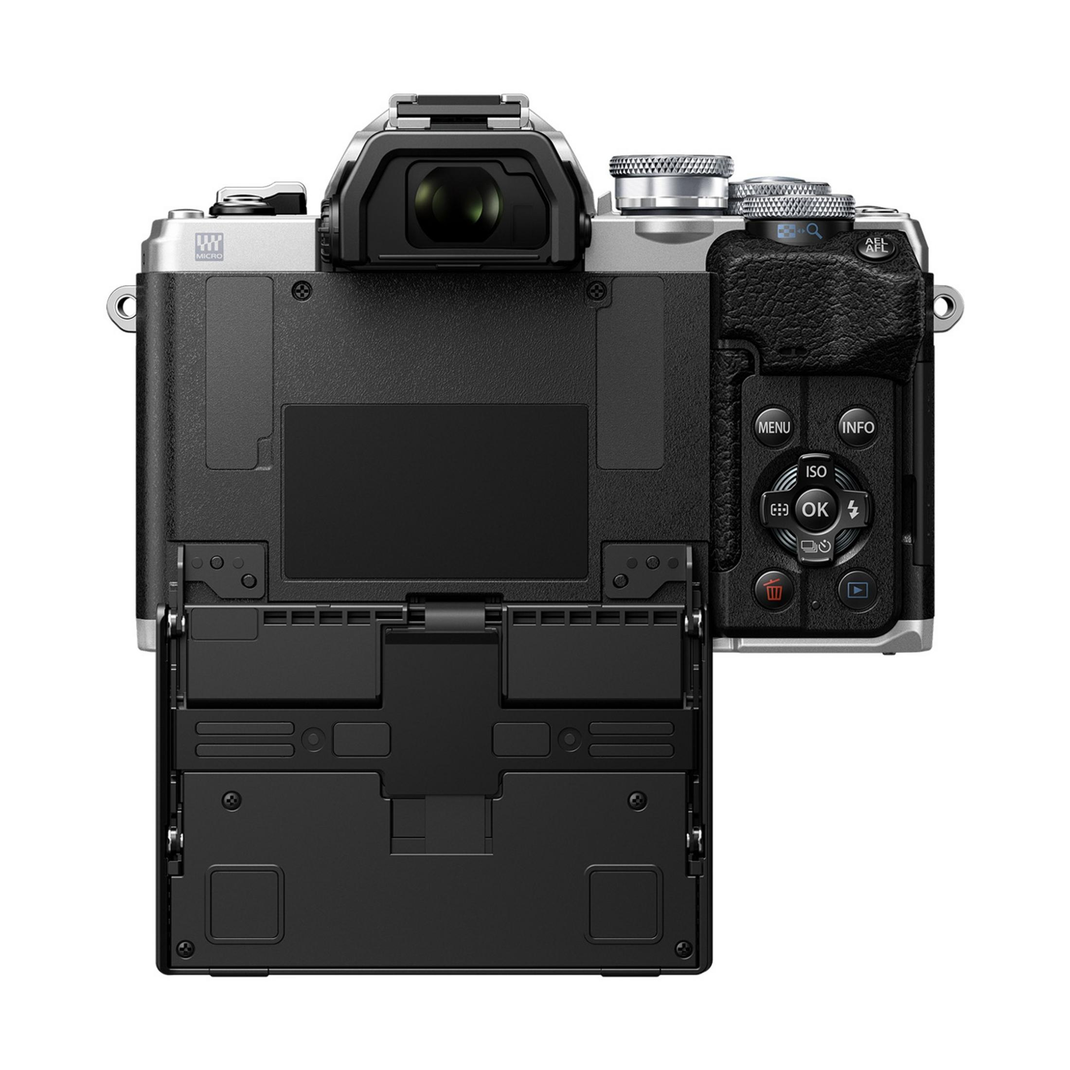 Retro di una fotocamera argento e nera con vano batteria aperto.