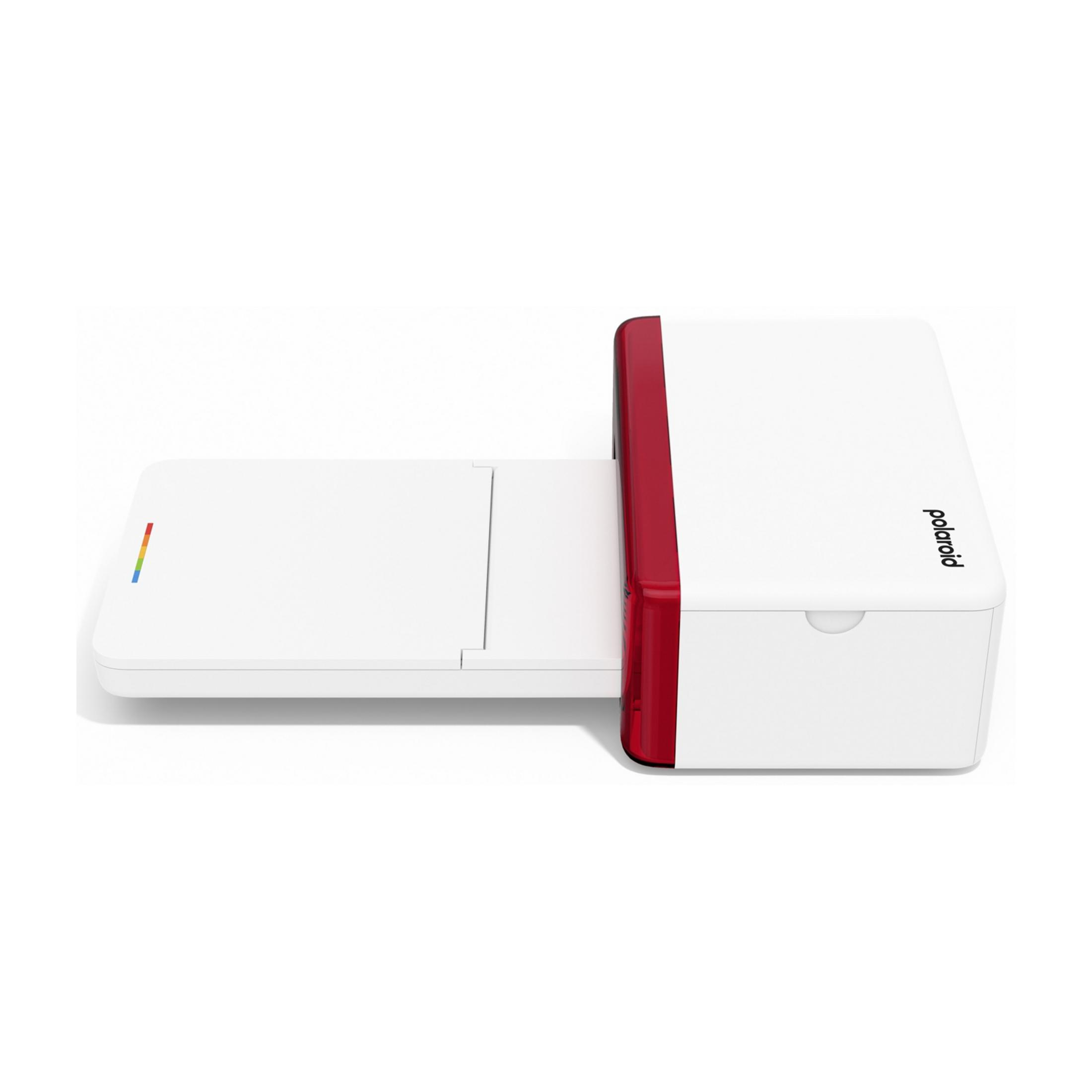 Biała drukarka Polaroid z czerwonym akcentem i wysuniętą tacką.