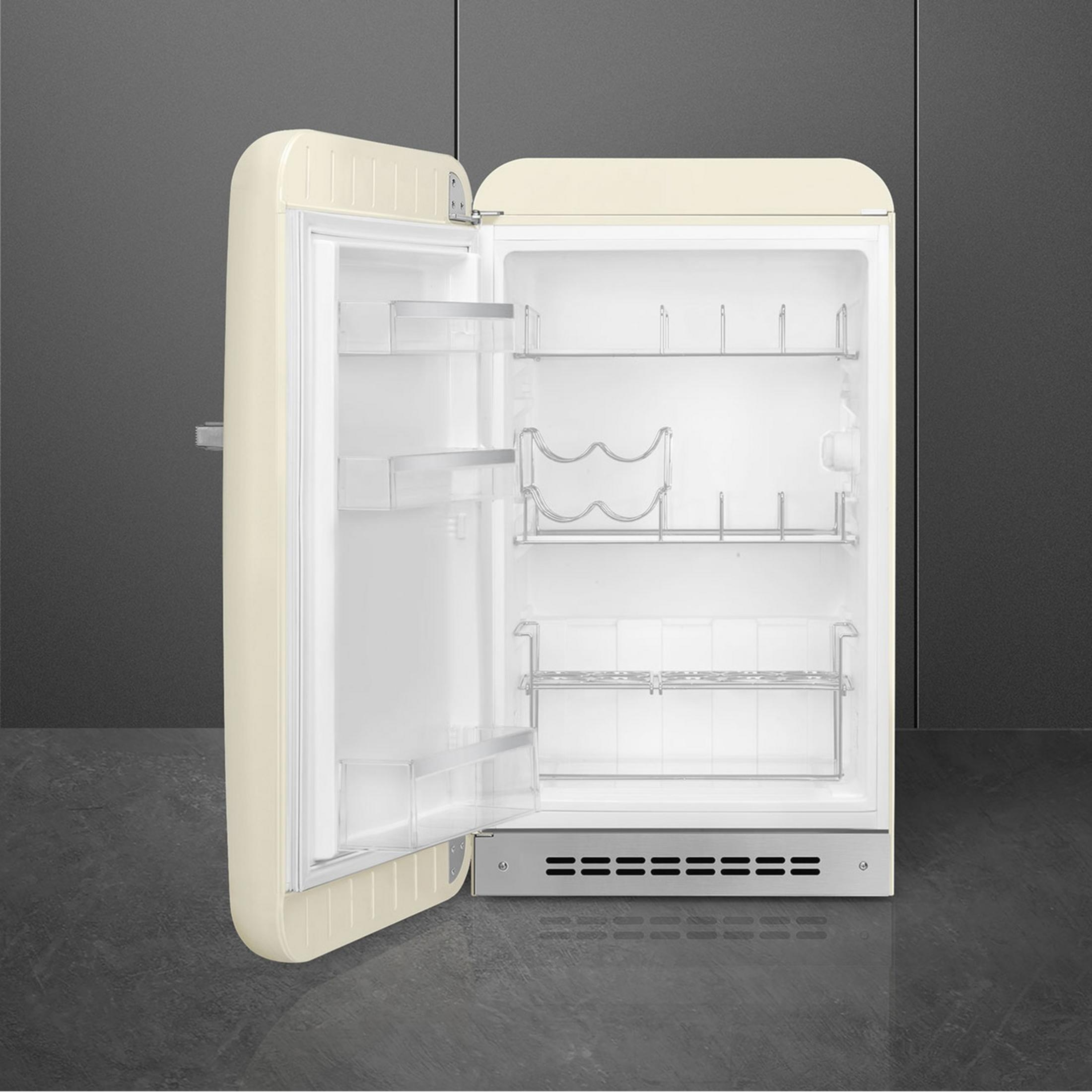 Un refrigerador abierto de color crema con estantes plateados y botelleros.