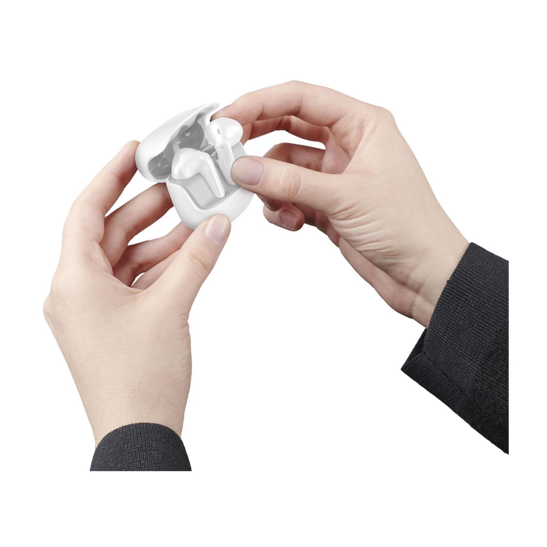 Manos colocando auriculares blancos en un estuche de carga blanco.