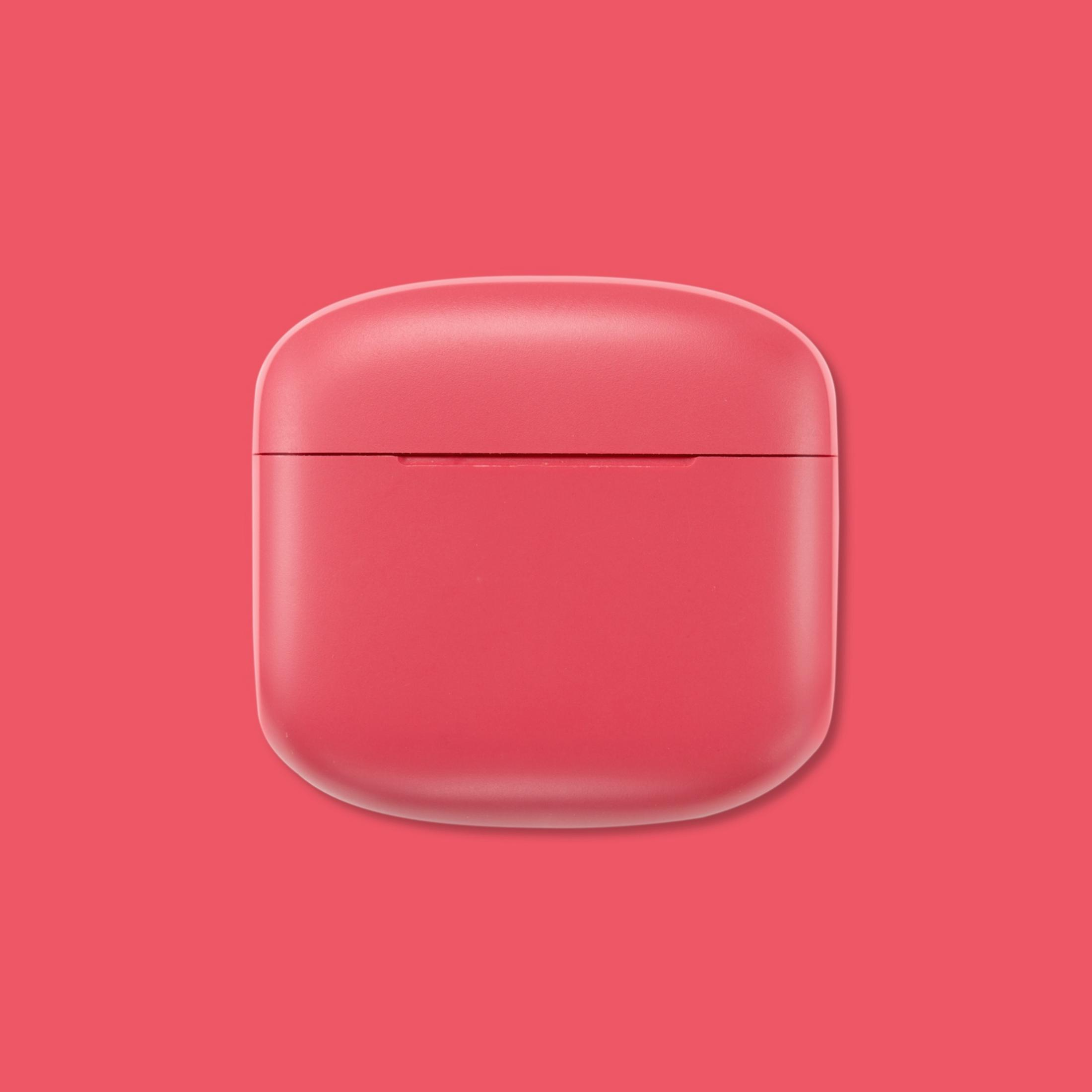 Un estuche de carga cerrado, rojo coral, para auriculares inalámbricos sobre fondo rojo coral.
