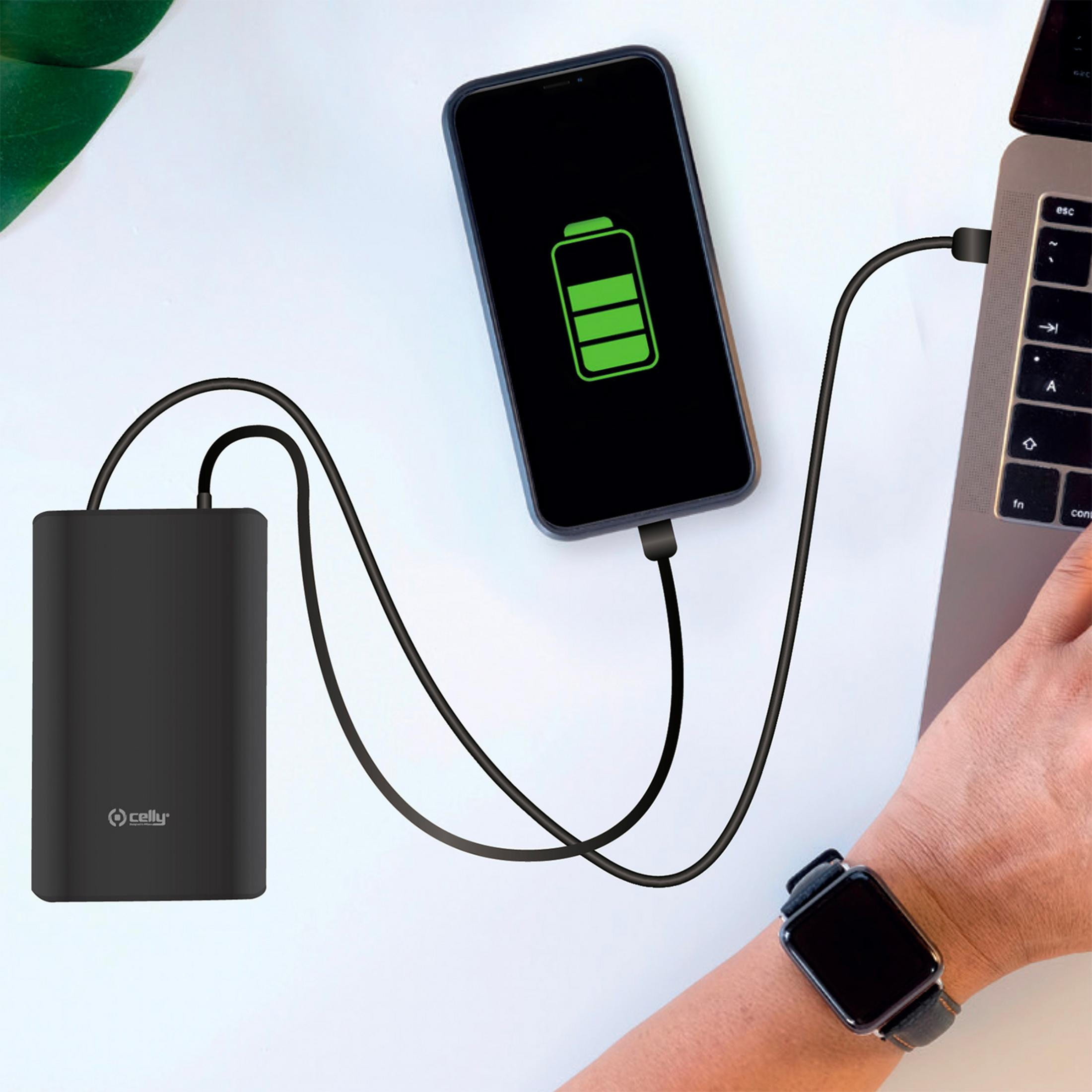 Ein schwarzes Powerbank lädt ein Smartphone, das an einen Laptop angeschlossen ist.