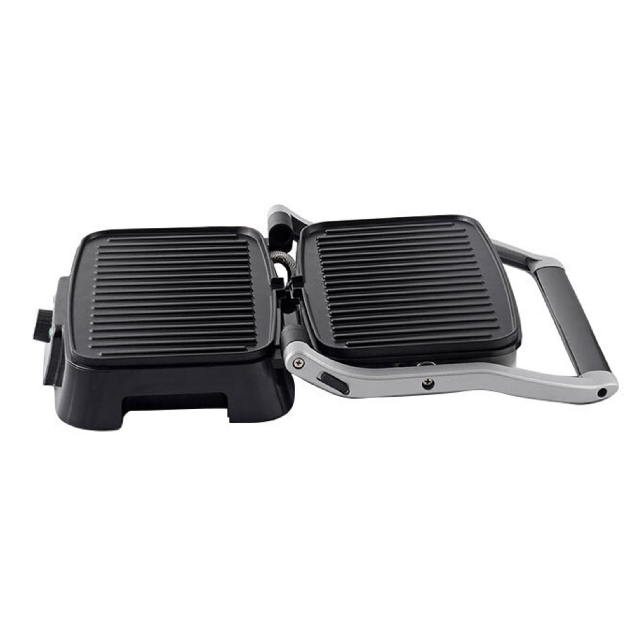 Un grill de contact noir ouvert avec des plaques nervurées et une poignée argentée.