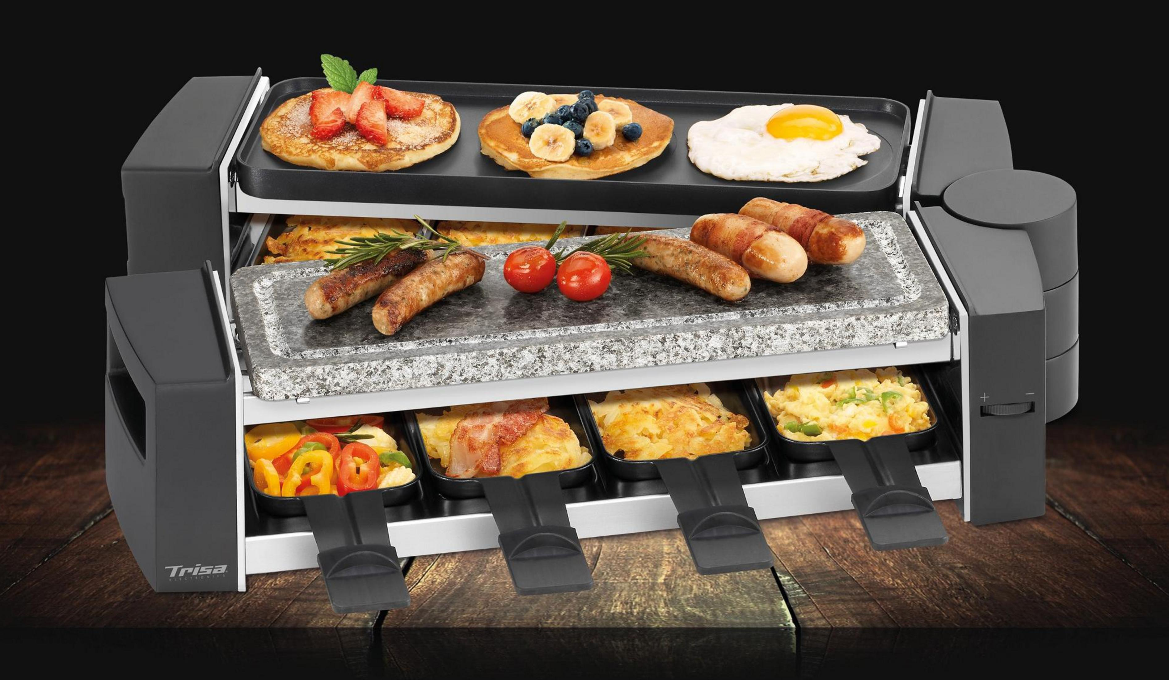 Ein Raclette-Grill mit Pfannkuchen, Speck, Würstchen, Eiern und Gemüse.