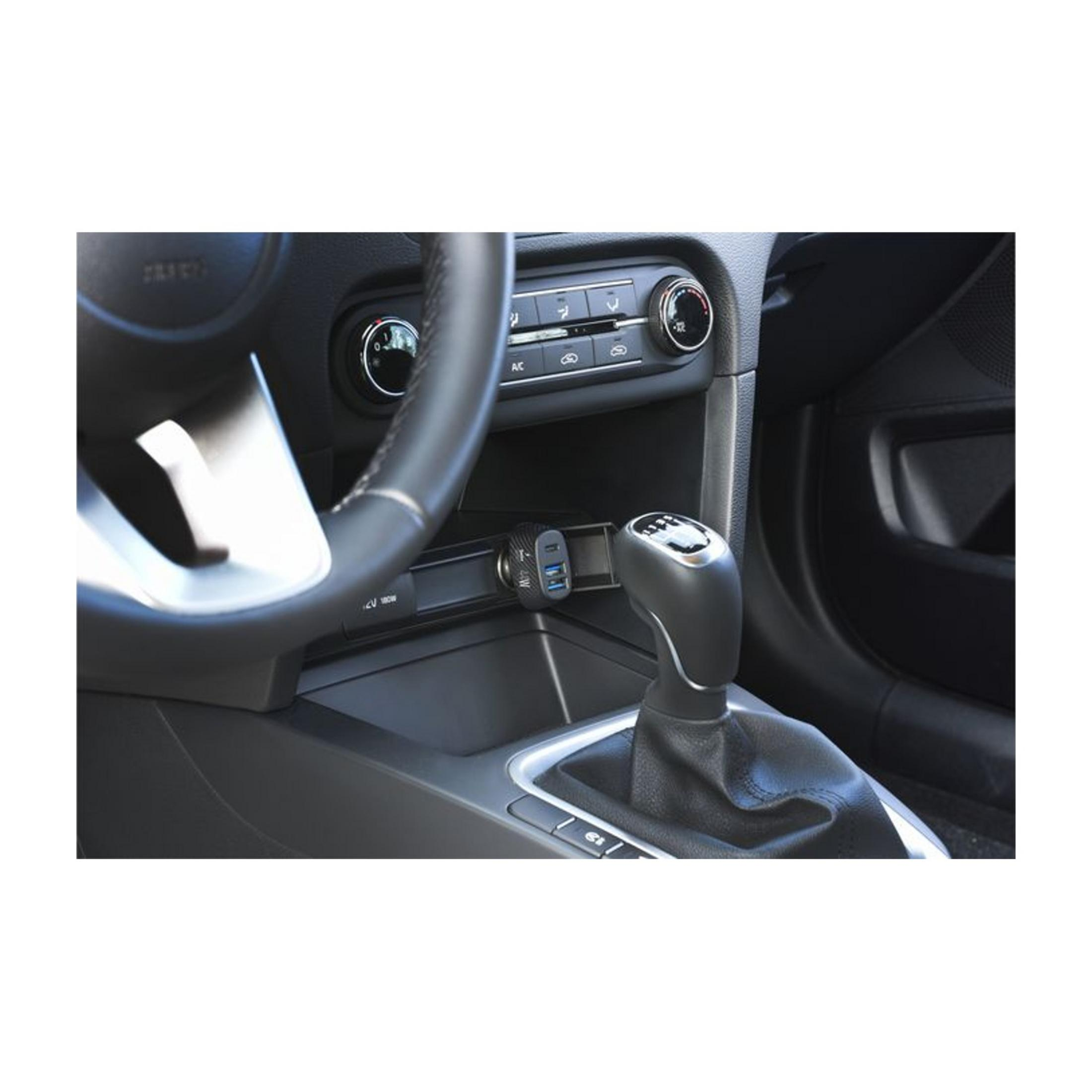 Innenraum eines Autos mit Schaltknüppel, Lenkrad und USB-Ladegerät.