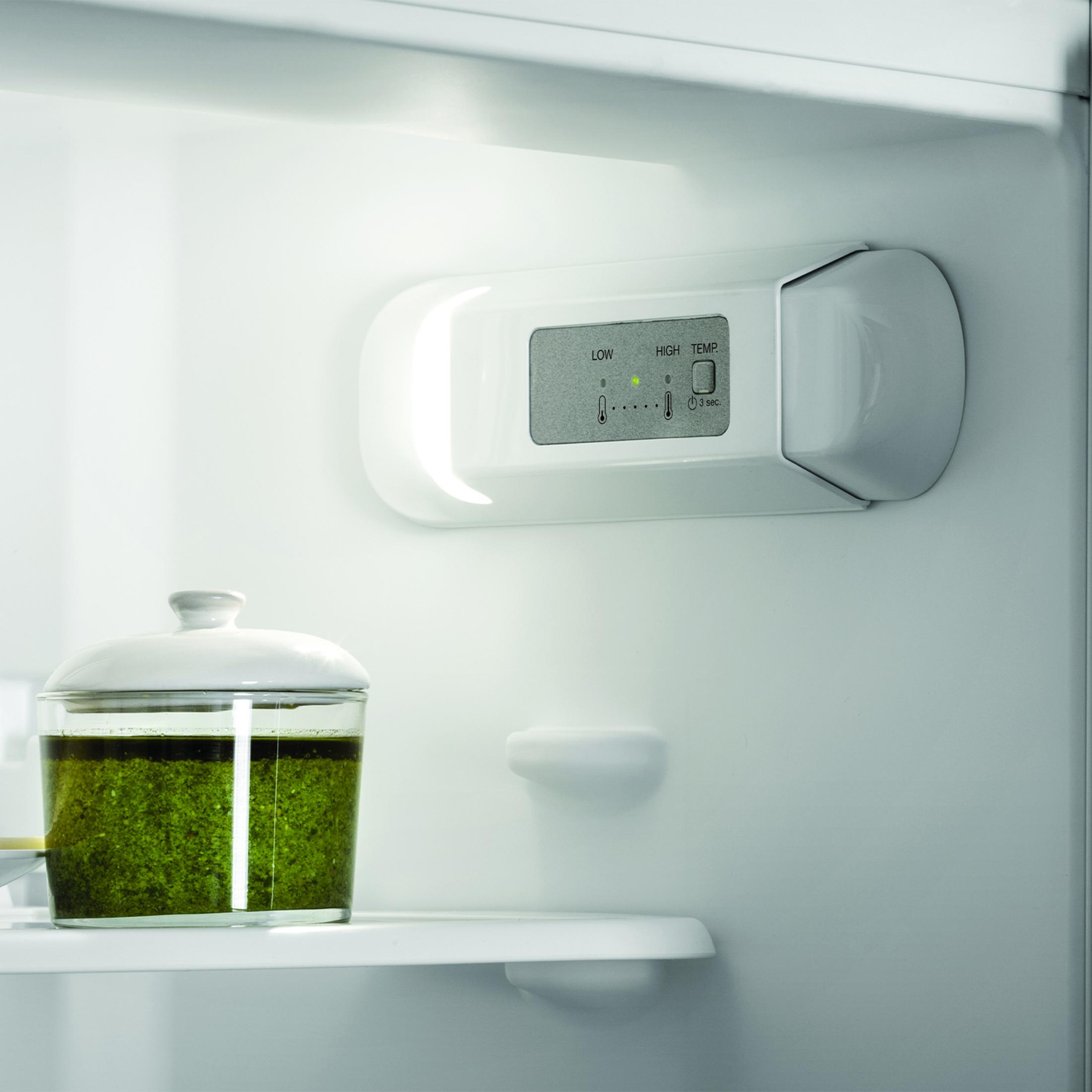 Crema verde in contenitore di vetro con coperchio in frigorifero.