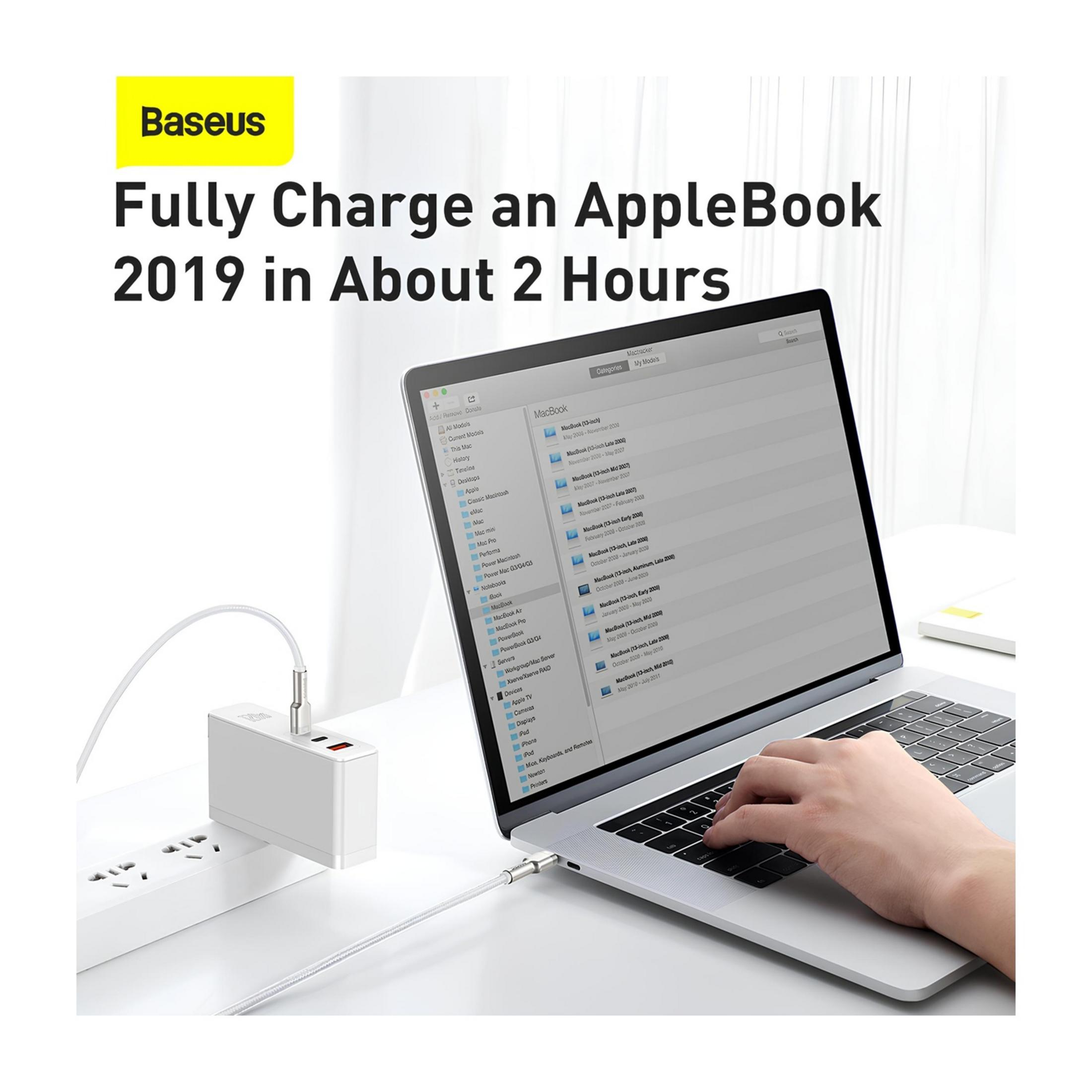 Un caricatore Baseus bianco è collegato a una ciabatta, accanto a un MacBook.