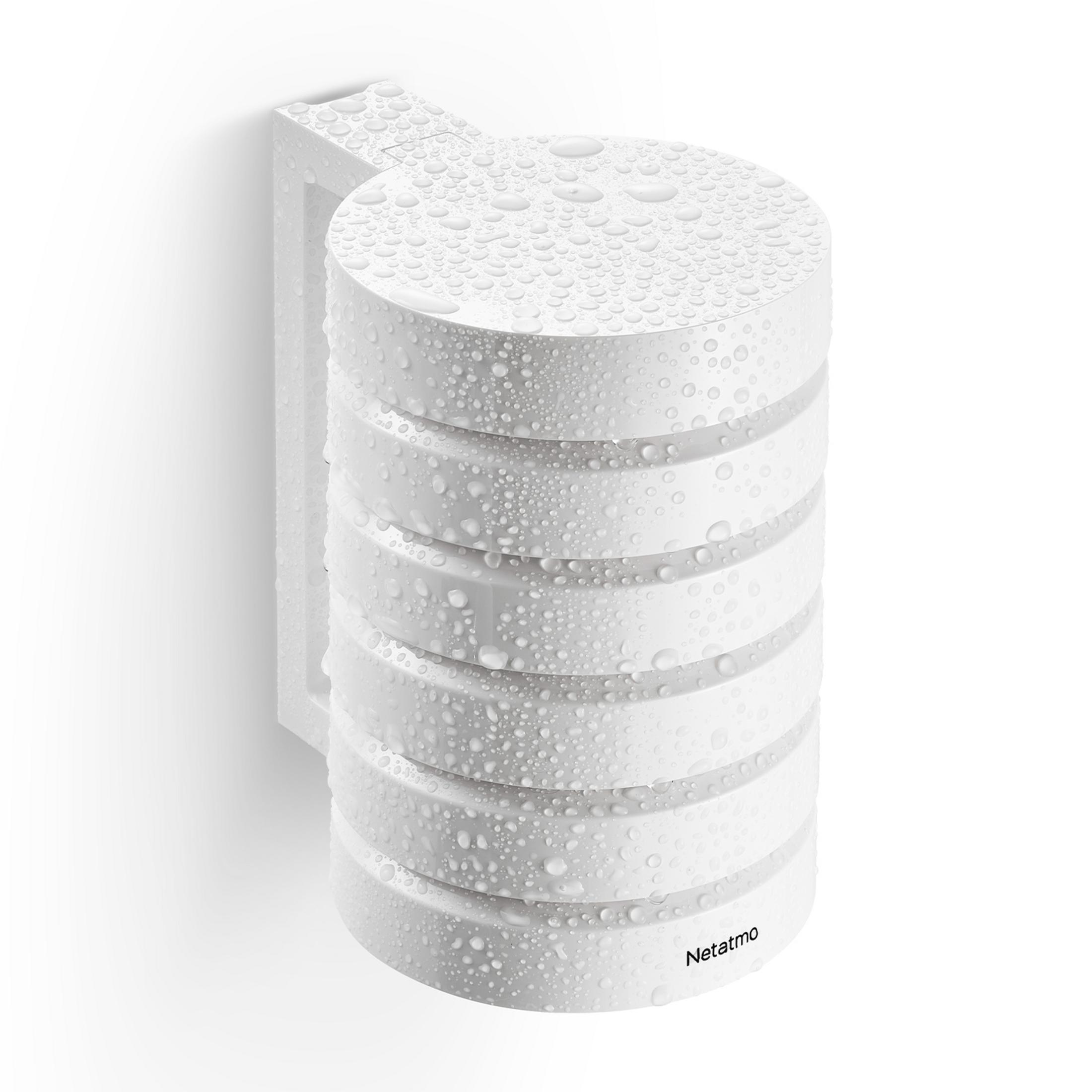 A white, cylindrical device with water droplets, mounted on a wall.