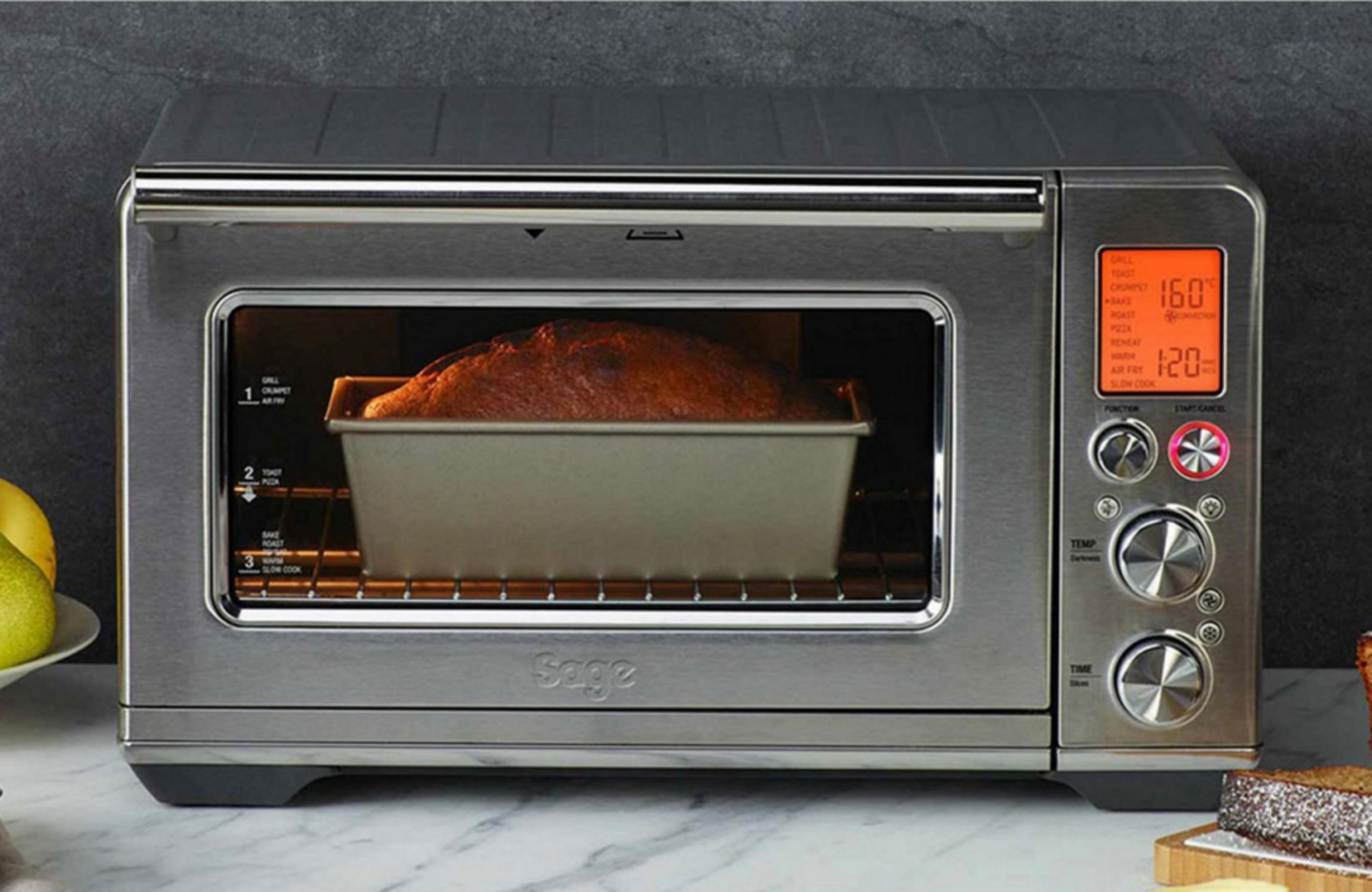 Un four grille-pain argenté avec du pain dans un moule à cake. L'écran affiche 160 degrés.