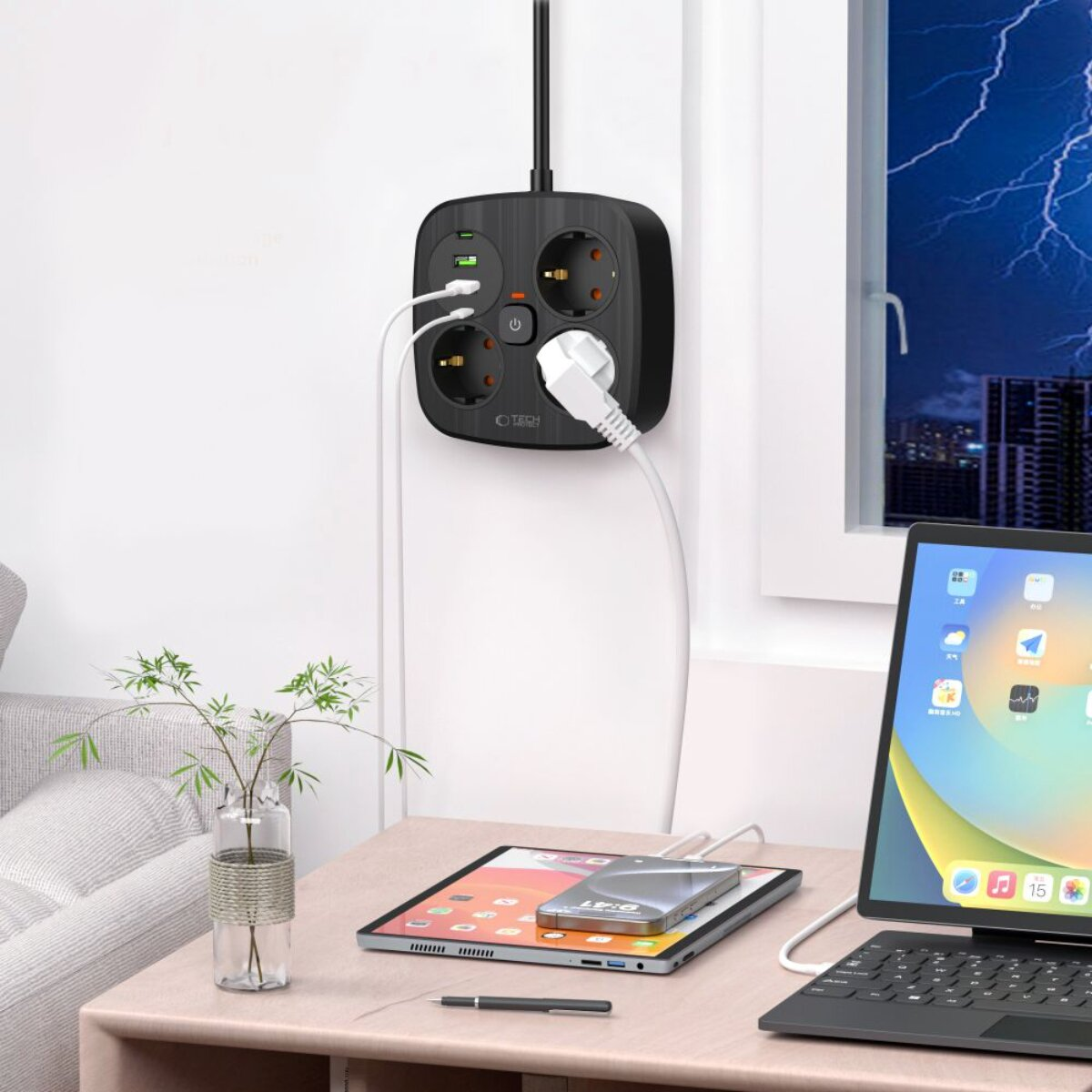 Schwarze Steckdosenleiste mit USB-Anschlüssen an einer Wand, lädt Geräte auf einem Tisch.
