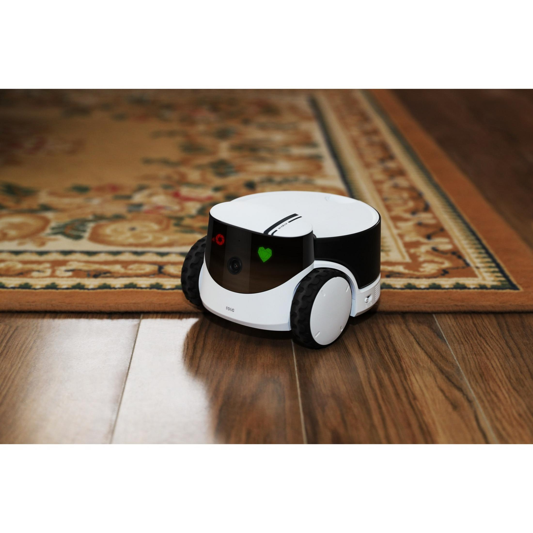 Ein weißer Roboter auf einem Holzboden neben einem Teppich.