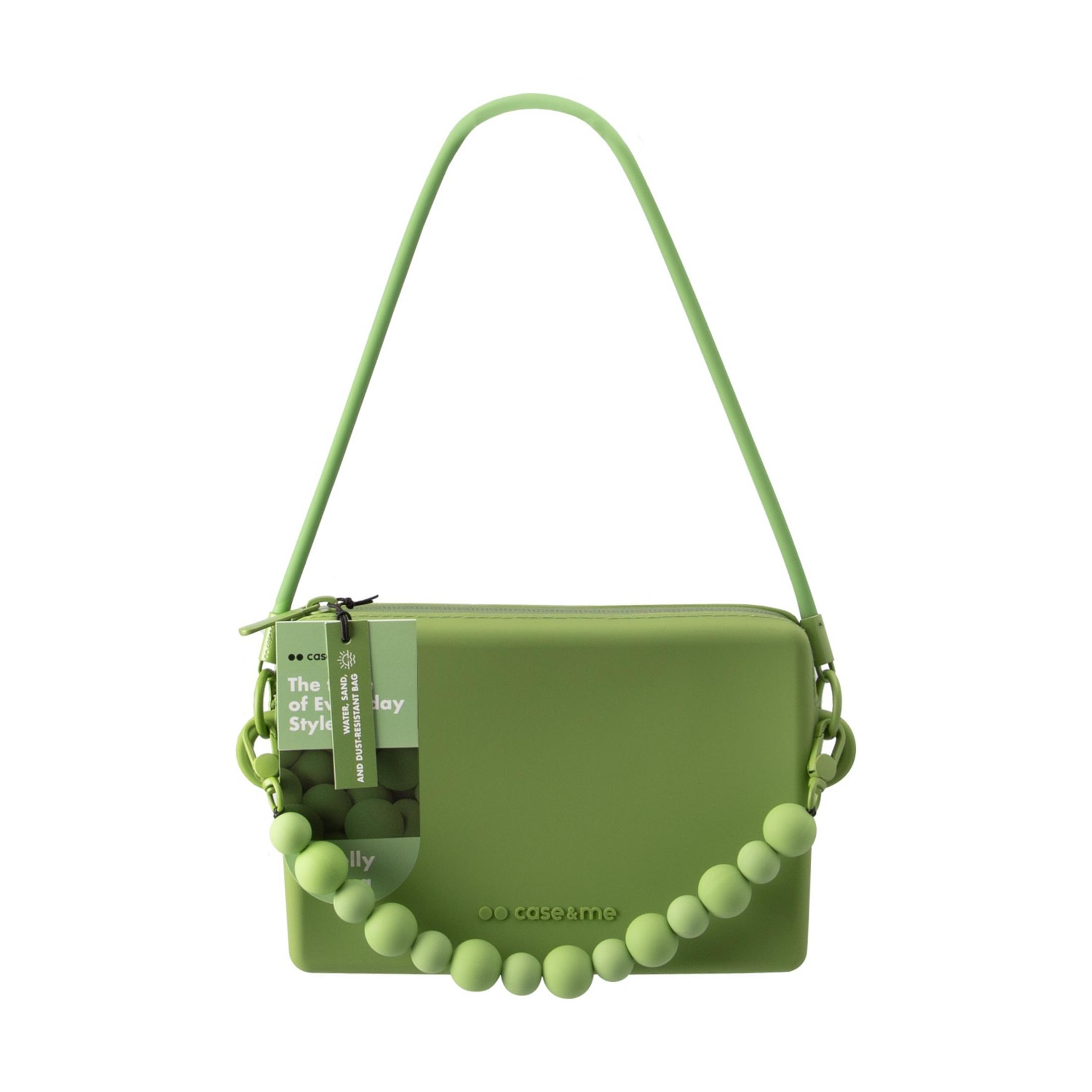 Un bolso verde con adornos de perlas y correa larga. Pegatina con texto.