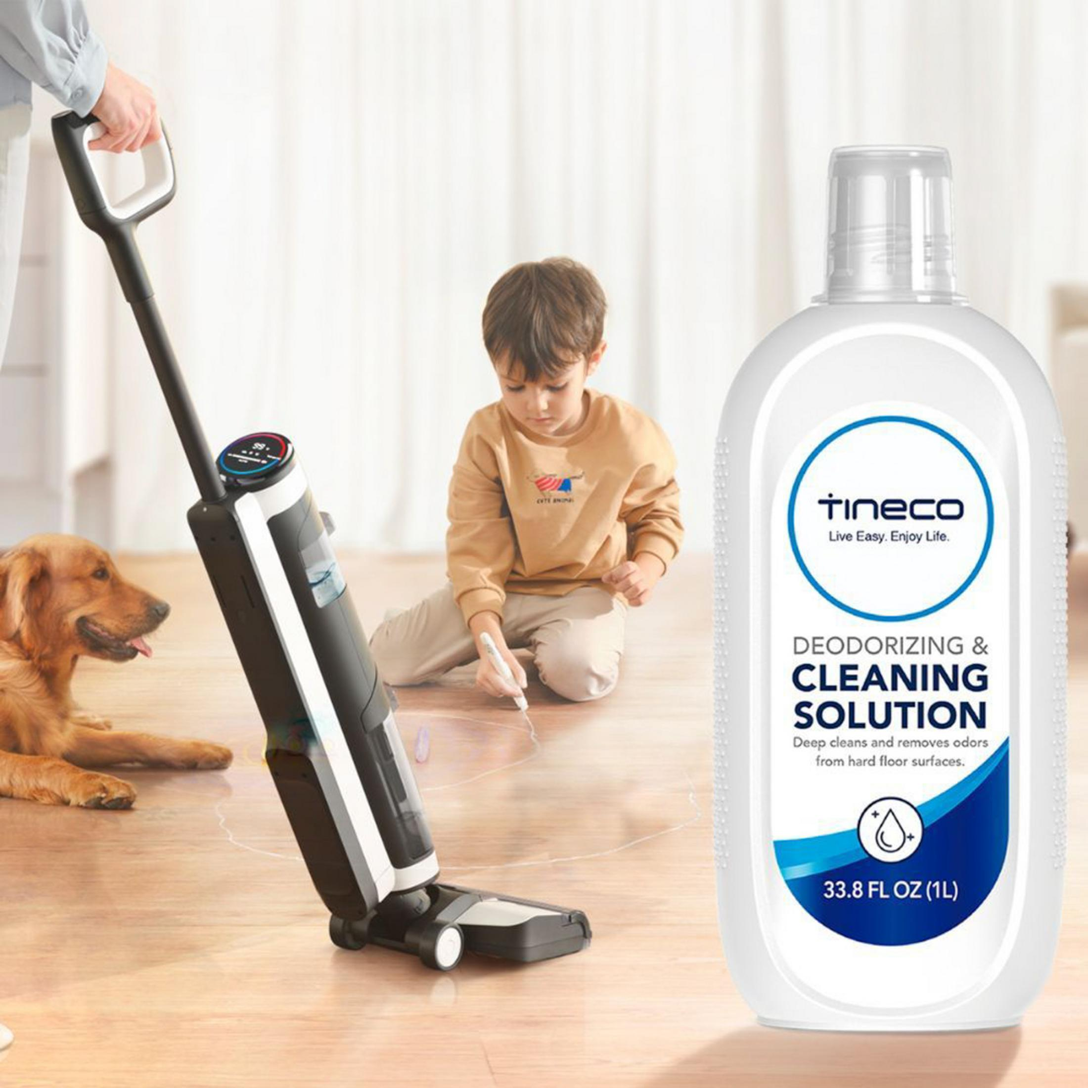 Cane, bambino e detergente per pavimenti su legno.