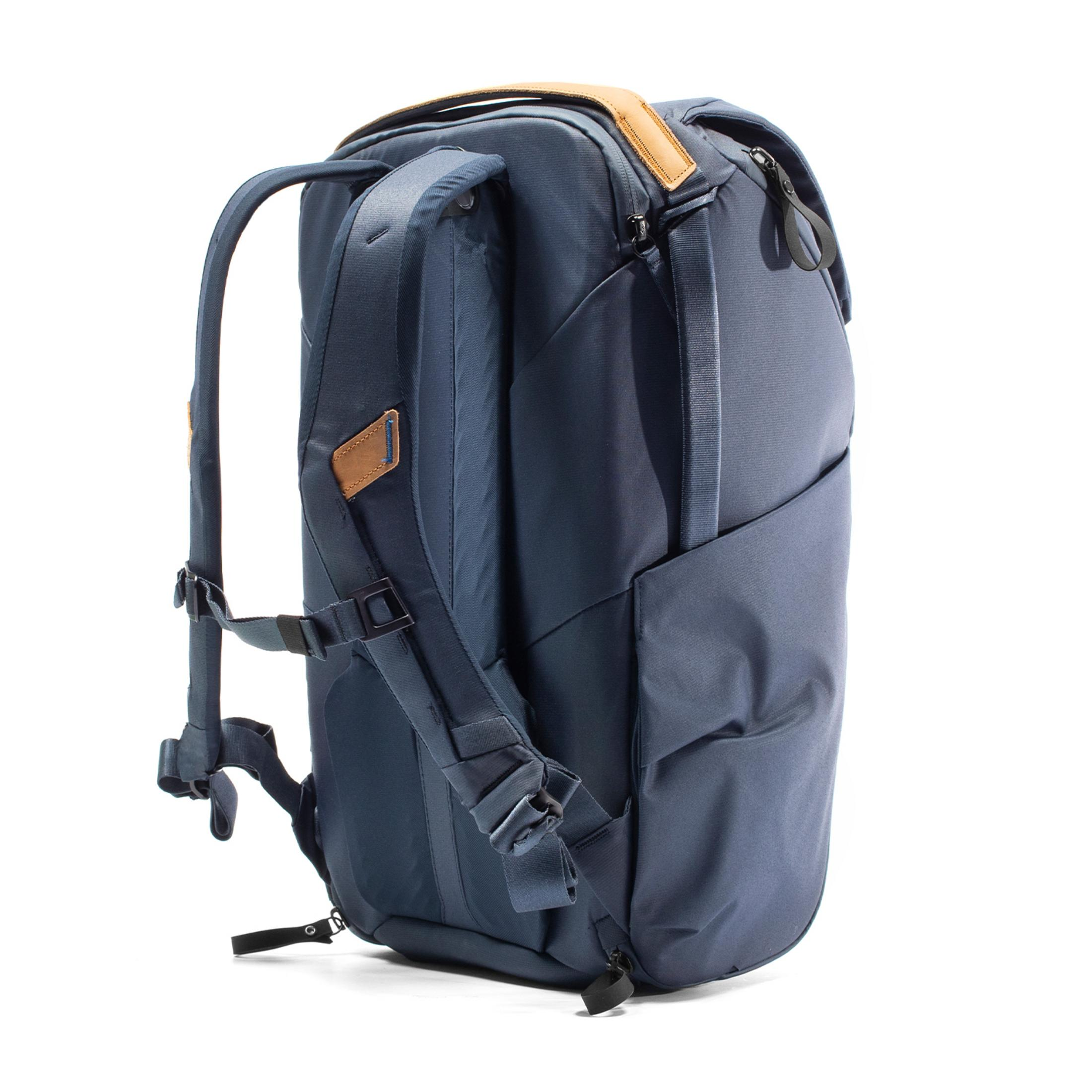 Ein dunkelblauer Rucksack mit braunen Lederakzenten, auf weißem Hintergrund.
