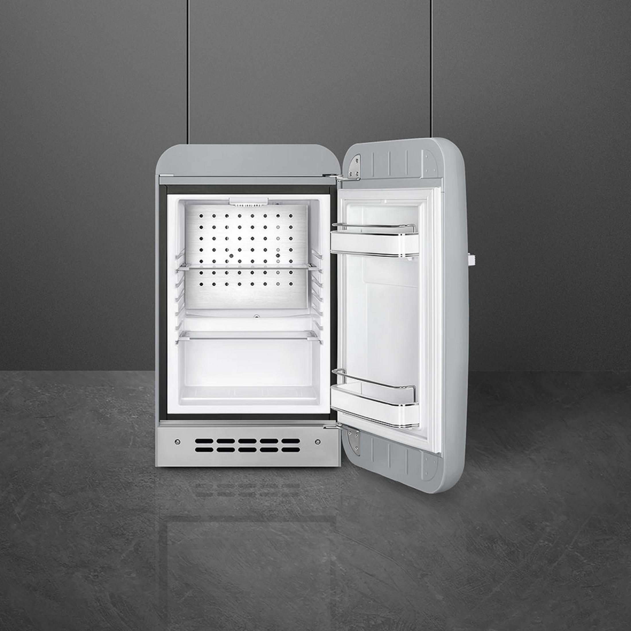 Un refrigerador gris con la puerta abierta, interior vacío.