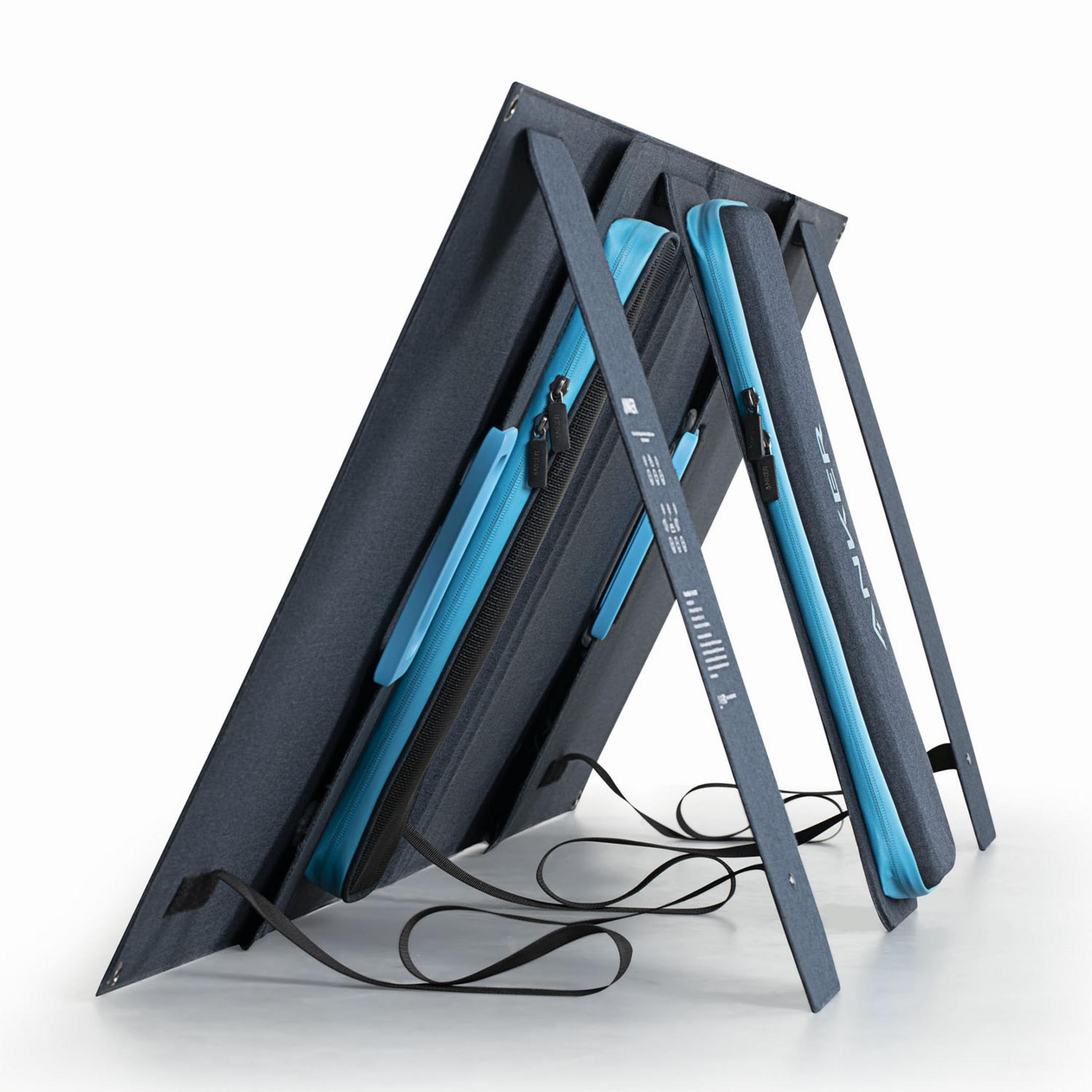 Ciemnoszary, składany panel słoneczny z niebieskimi kieszeniami na zamek, podparty na stojakach.