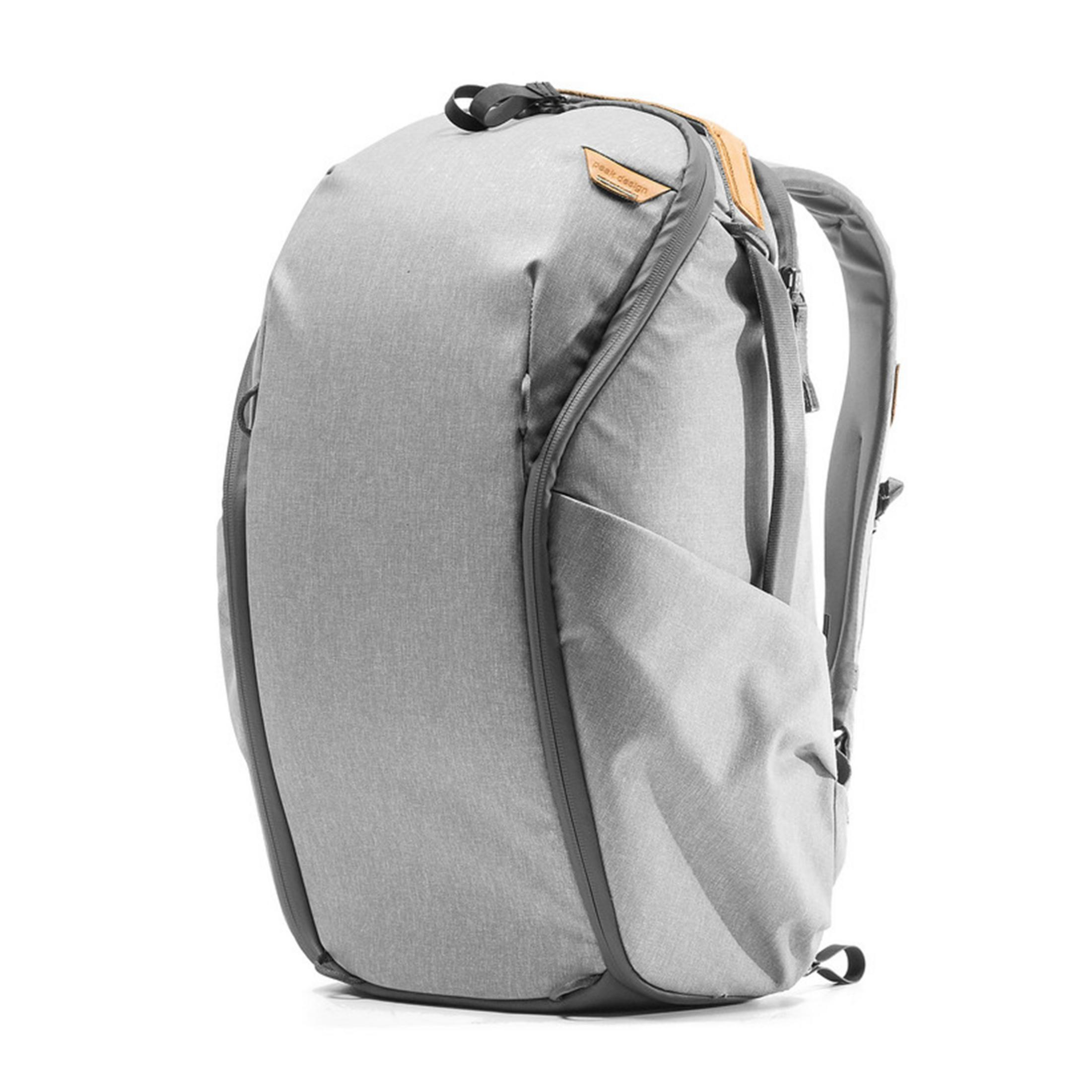 Zaino grigio con accenti in pelle e cerniere, su sfondo bianco.