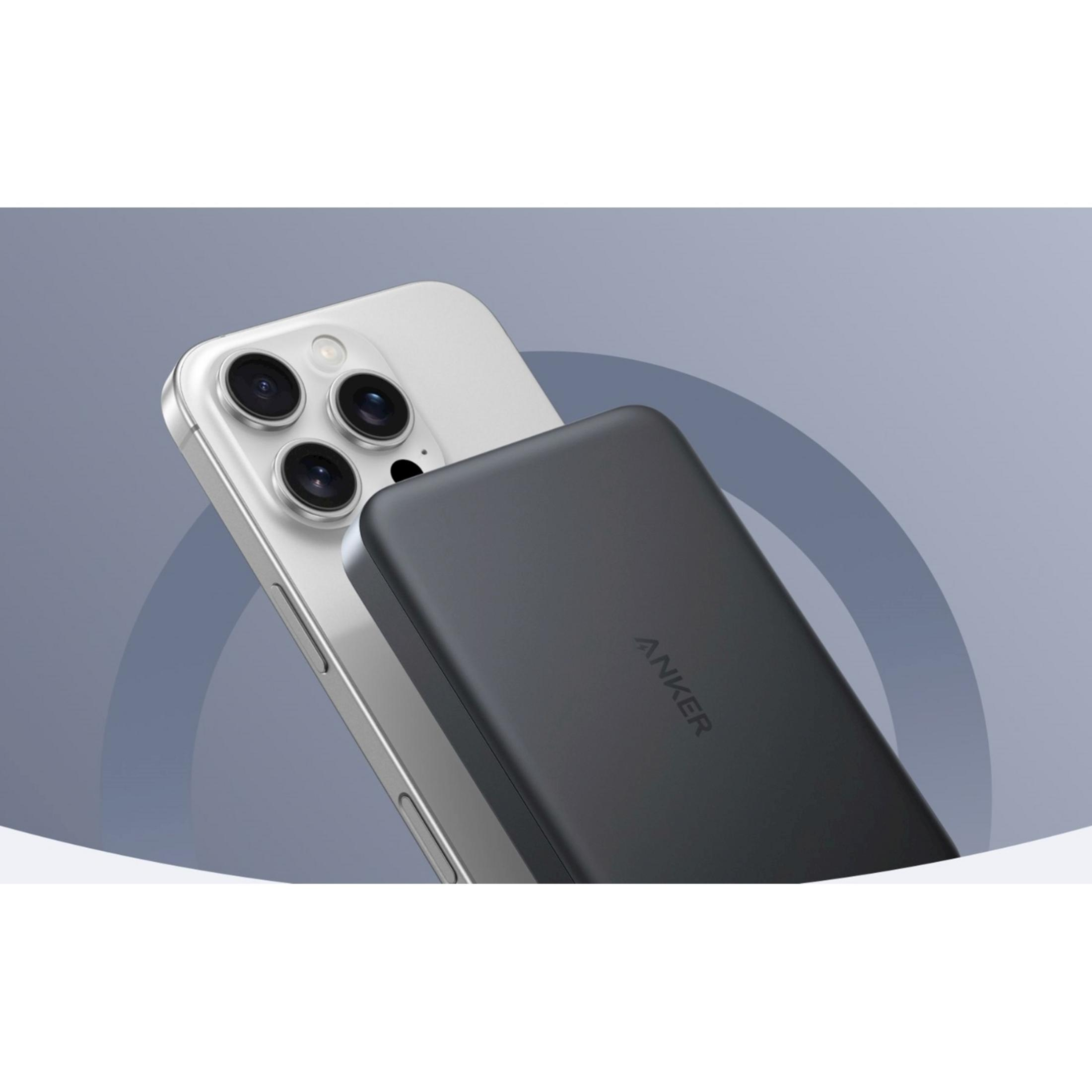 Ein dunkler Anker-Powerbank liegt auf einem silbernen Smartphone mit drei Kameras.