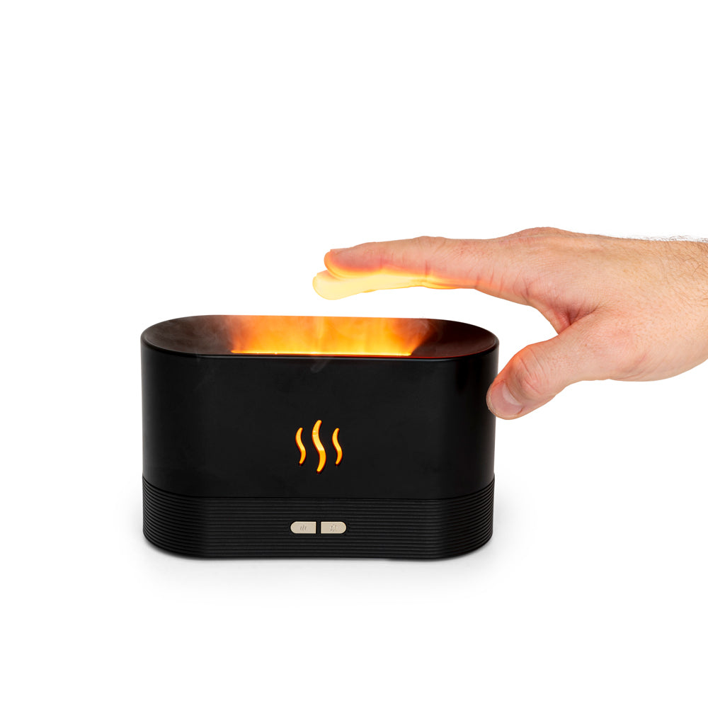 Hand über einem schwarzen Gerät mit Flammen-Effekt und Dampf.