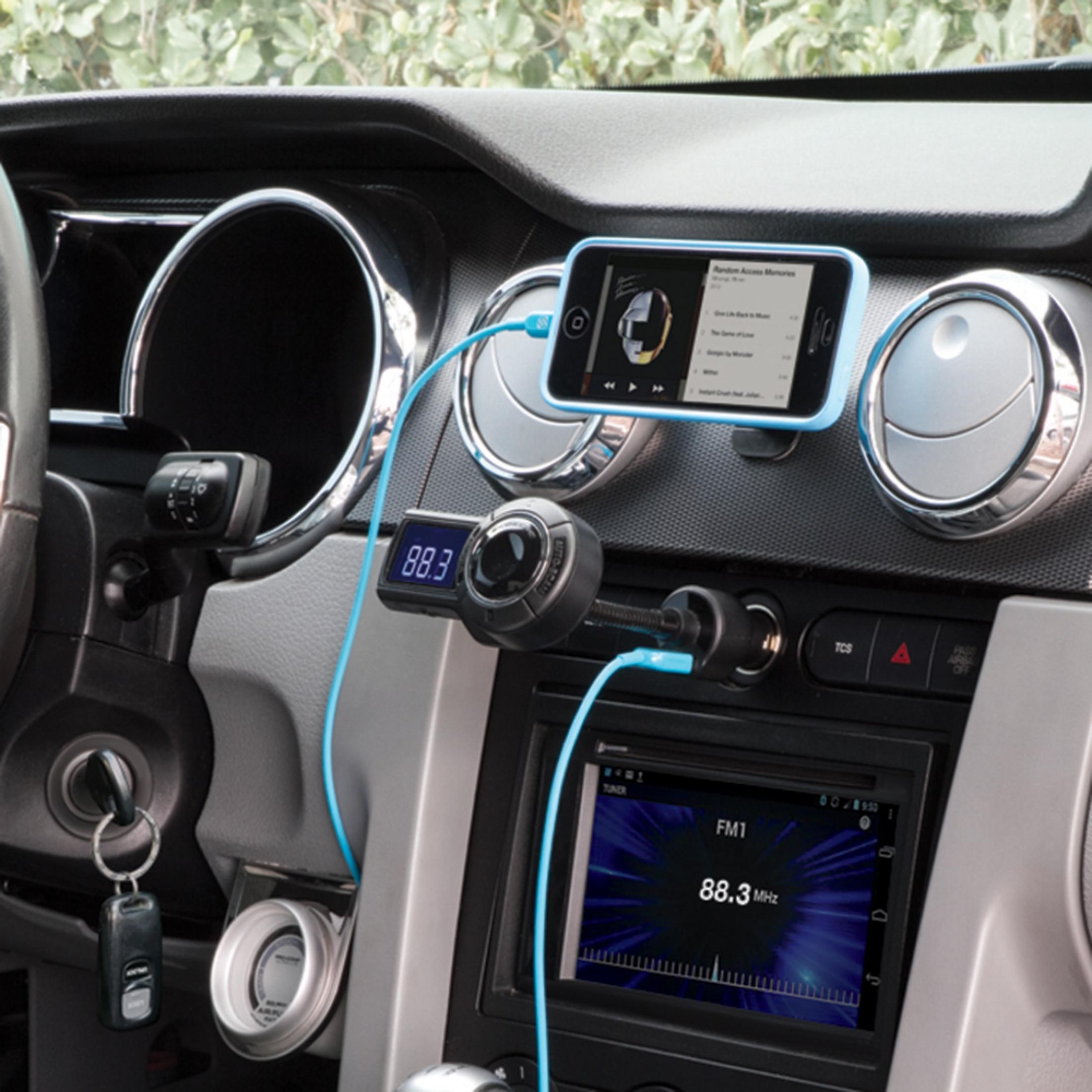 Autoinnenraum mit Smartphone, FM-Sender und Autoradio.