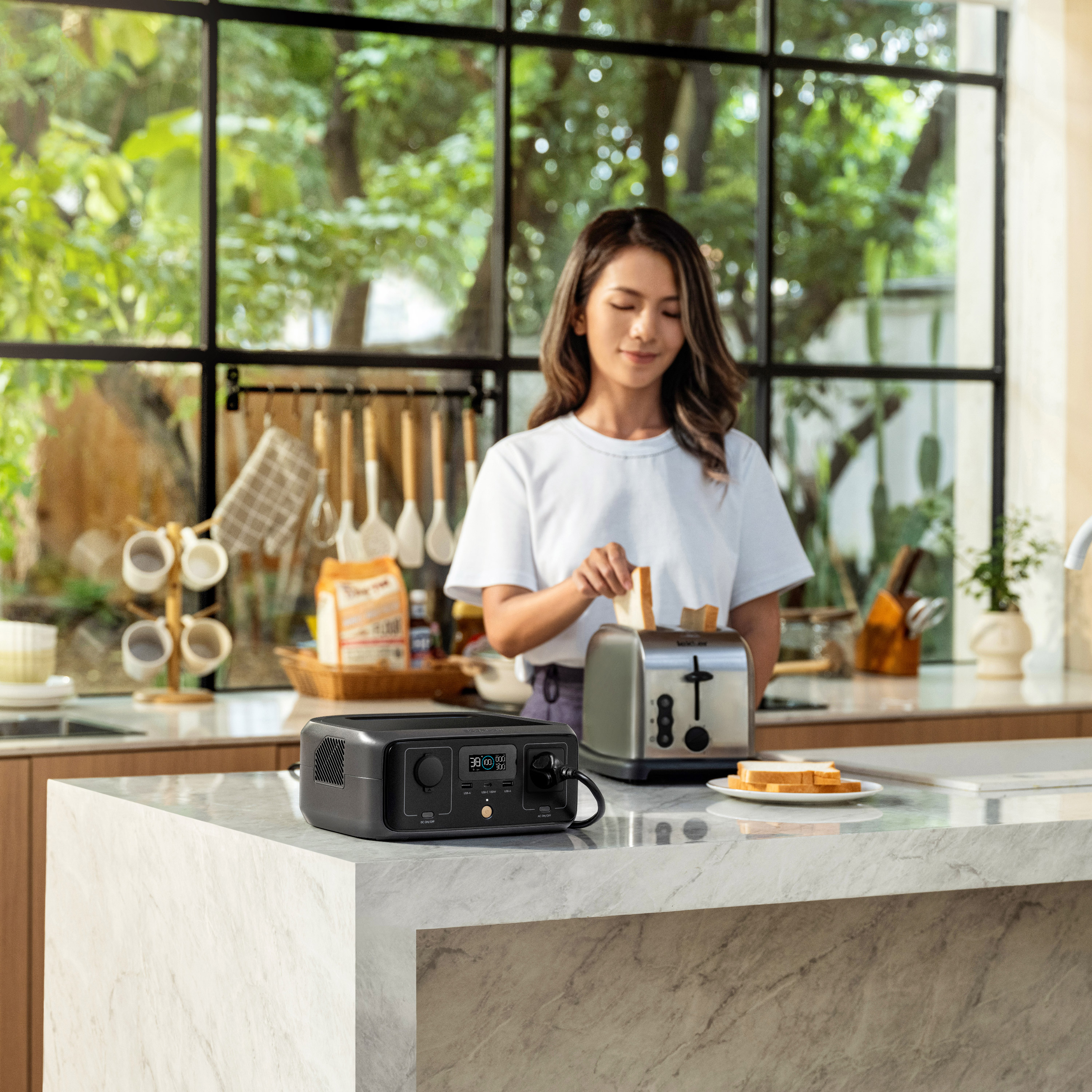 Kobieta wkłada chleb do tostera; agregat i talerz z chlebem na blacie.