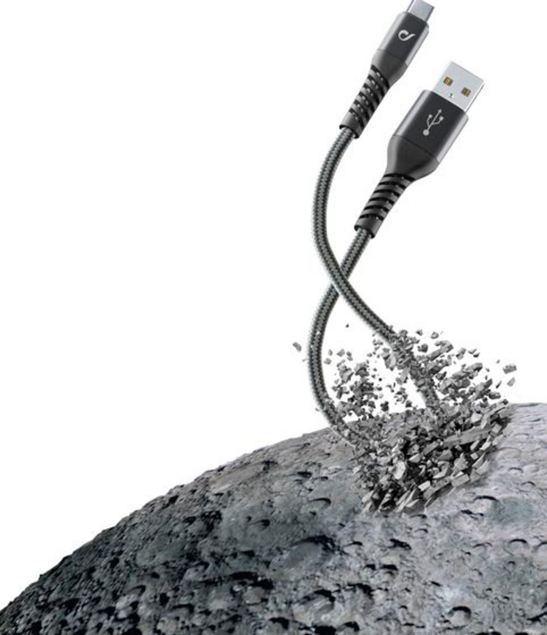 Un cable USB-C rompiendo roca gris.