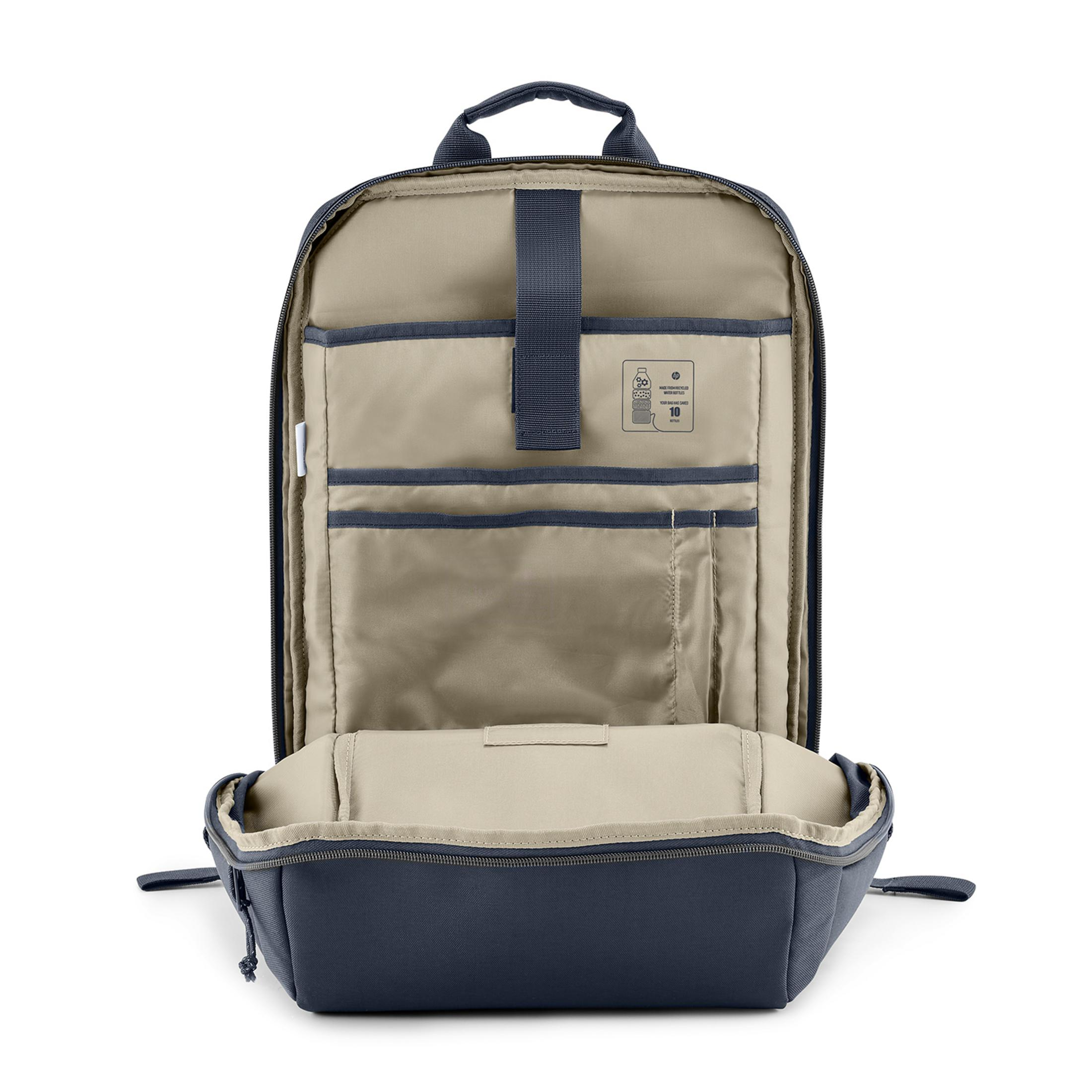 Zaino blu scuro aperto con interno chiaro, tasche e manico superiore.