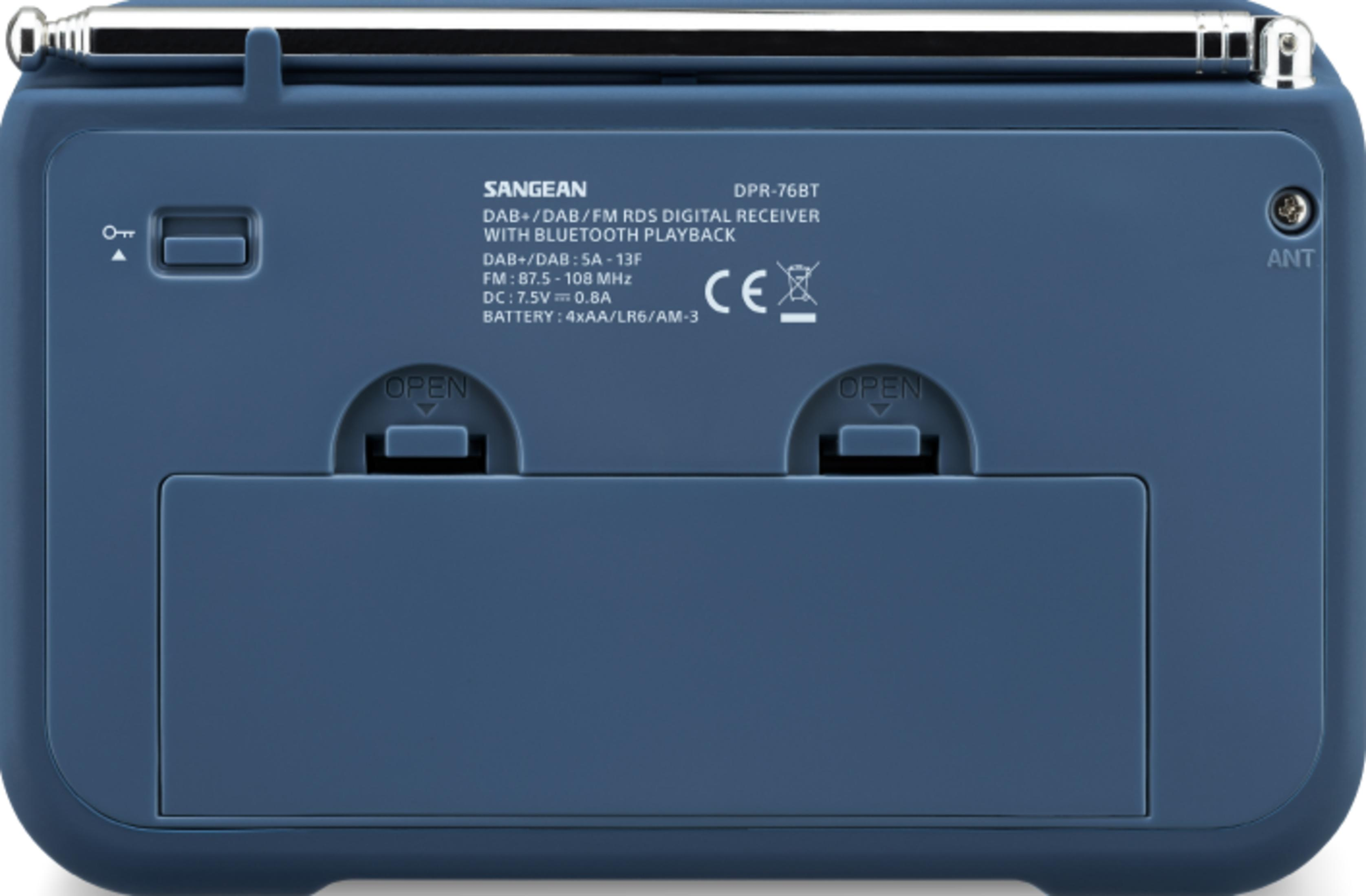Arrière d'une radio bleue avec antenne, étiquettes et compartiment batterie.