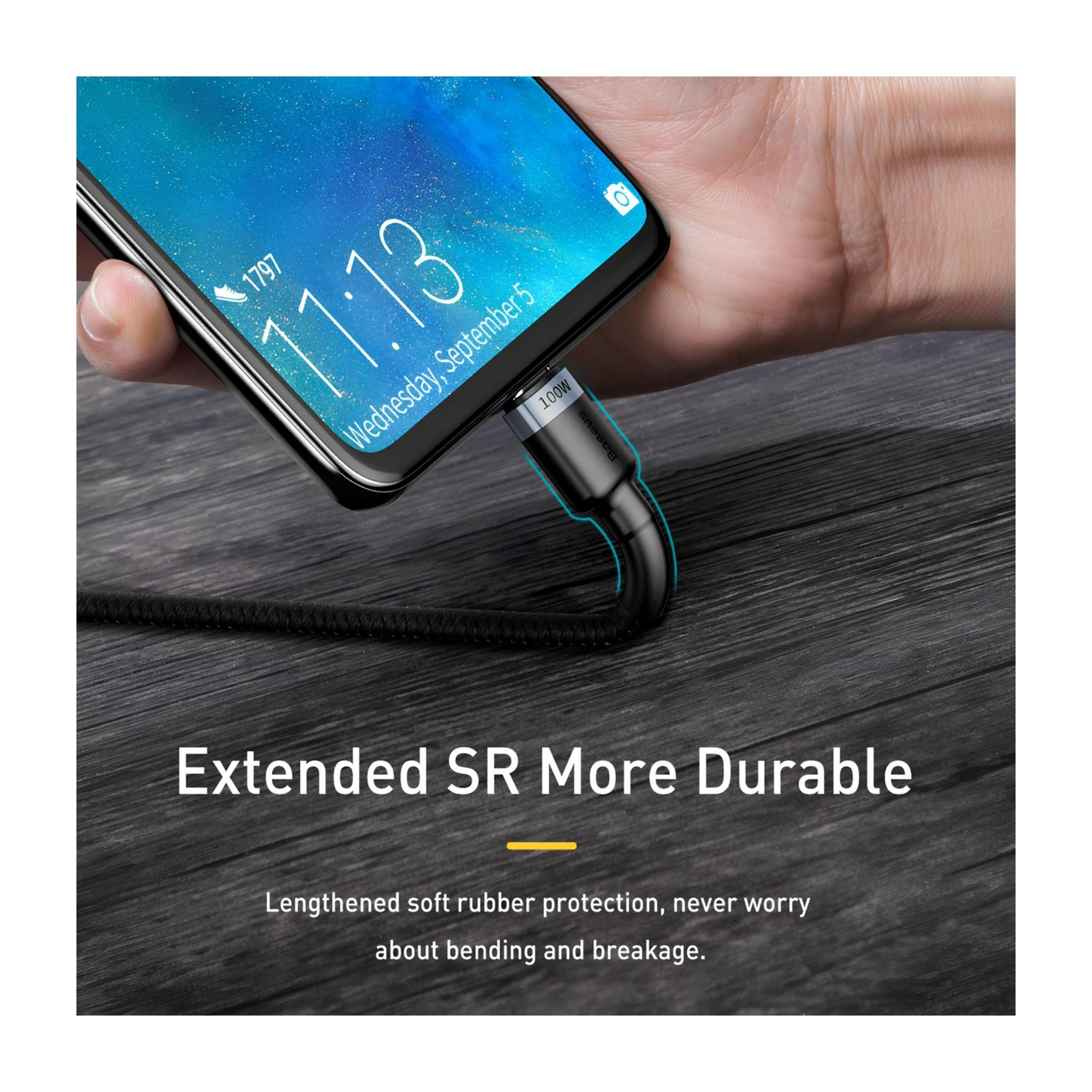 Ręka trzyma telefon ładujący się czarnym kablem z napisem 100W.