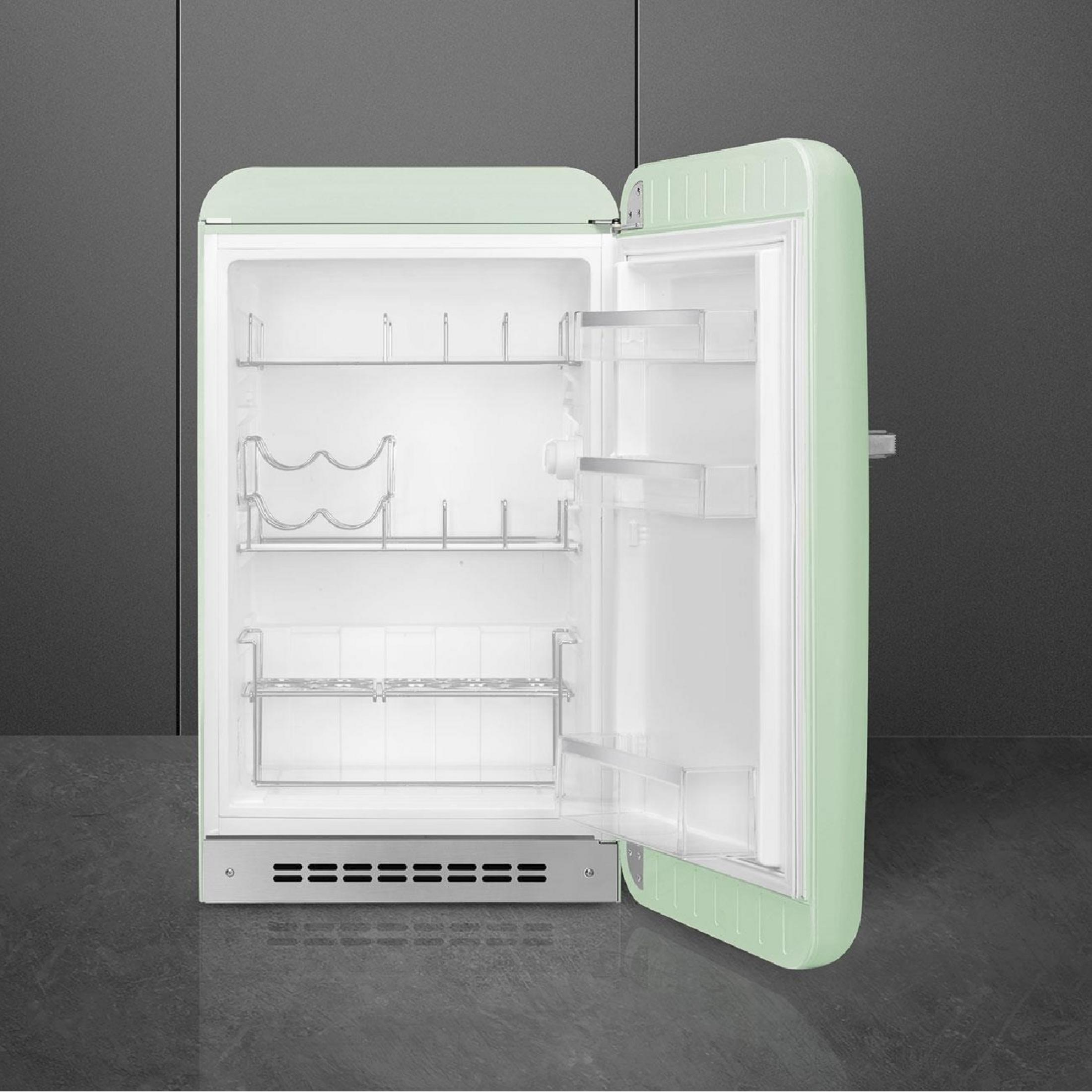 Un refrigerador abierto, verde claro, con estantes plateados y botelleros.