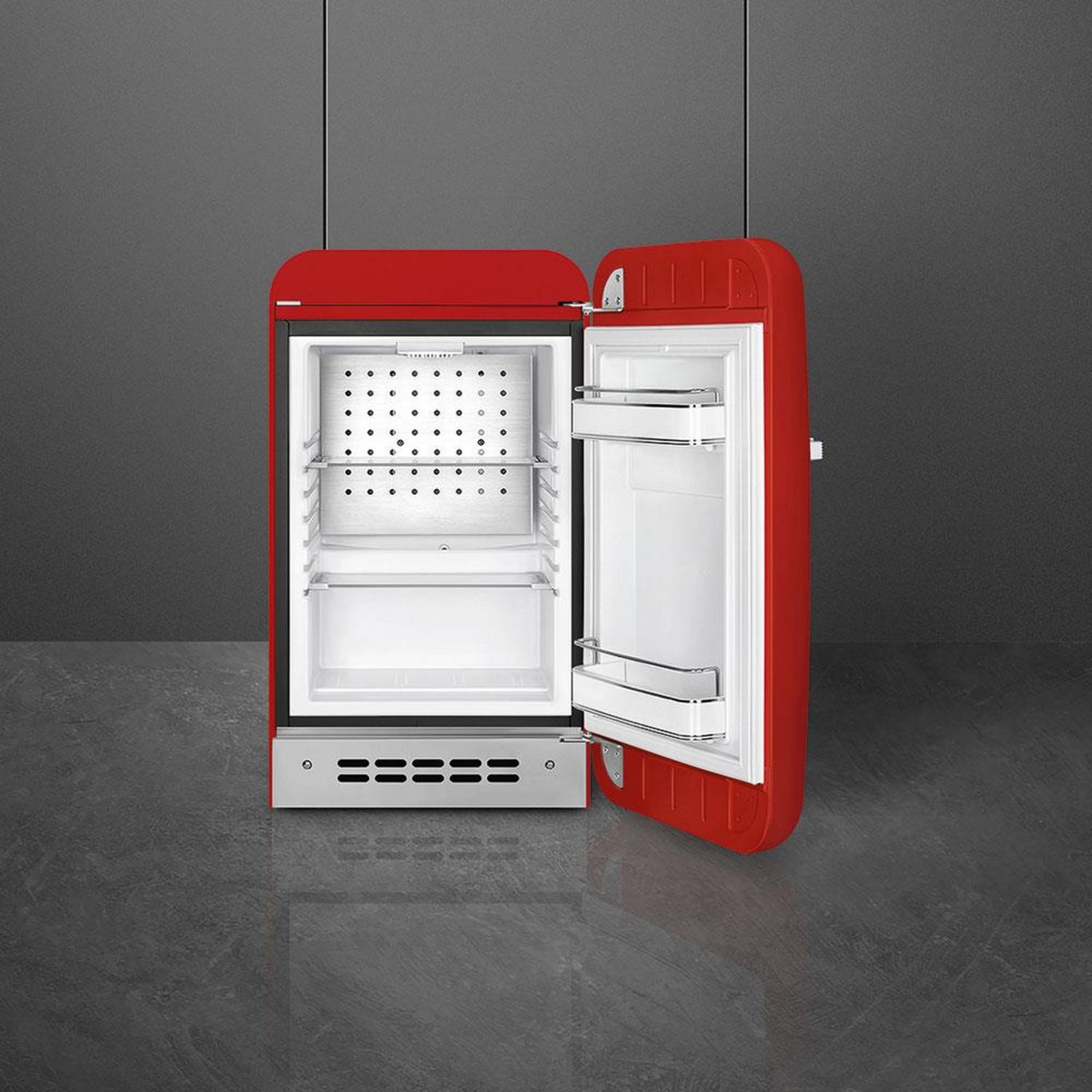 Un refrigerador rojo con la puerta abierta, mostrando estantes interiores.