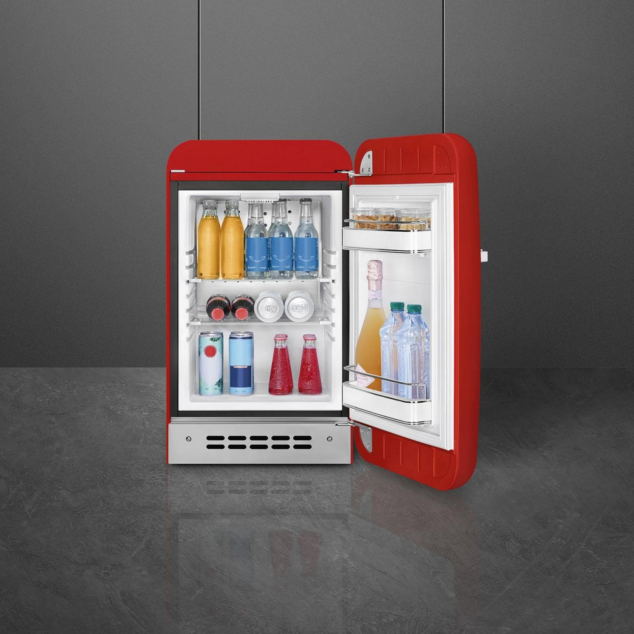 Un refrigerador rojo con la puerta abierta, lleno de bebidas.