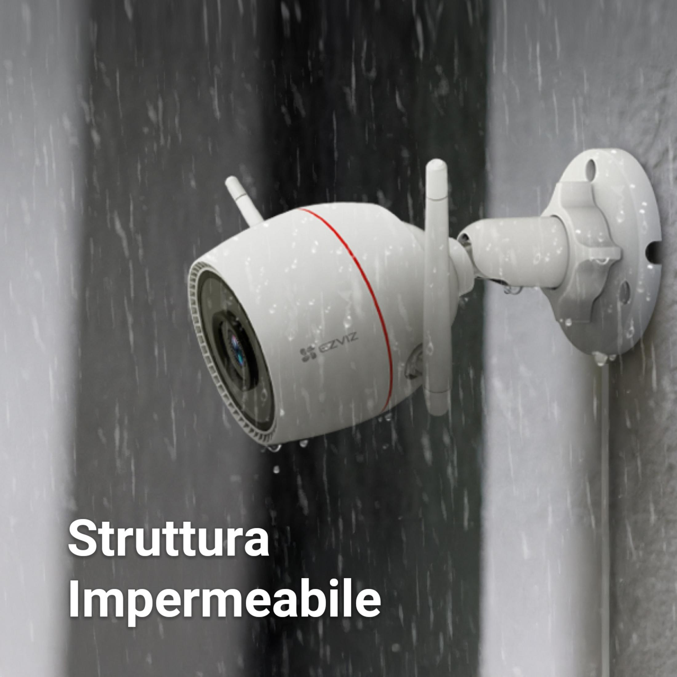 Biała kamera bezpieczeństwa z antenami zamontowana na ścianie w deszczu.