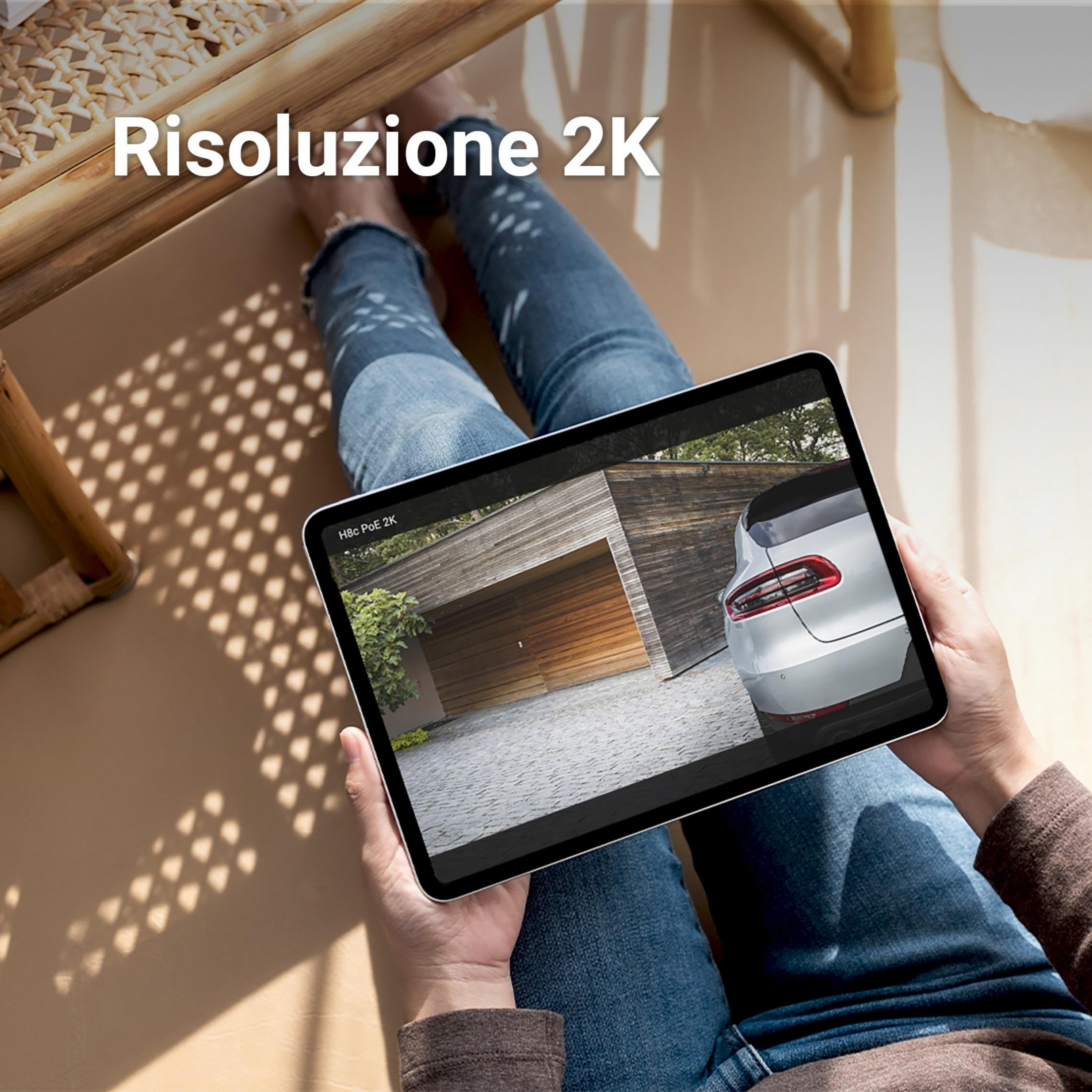 Osoba trzyma tablet z widokiem z kamery bezpieczeństwa nowoczesnego domu.