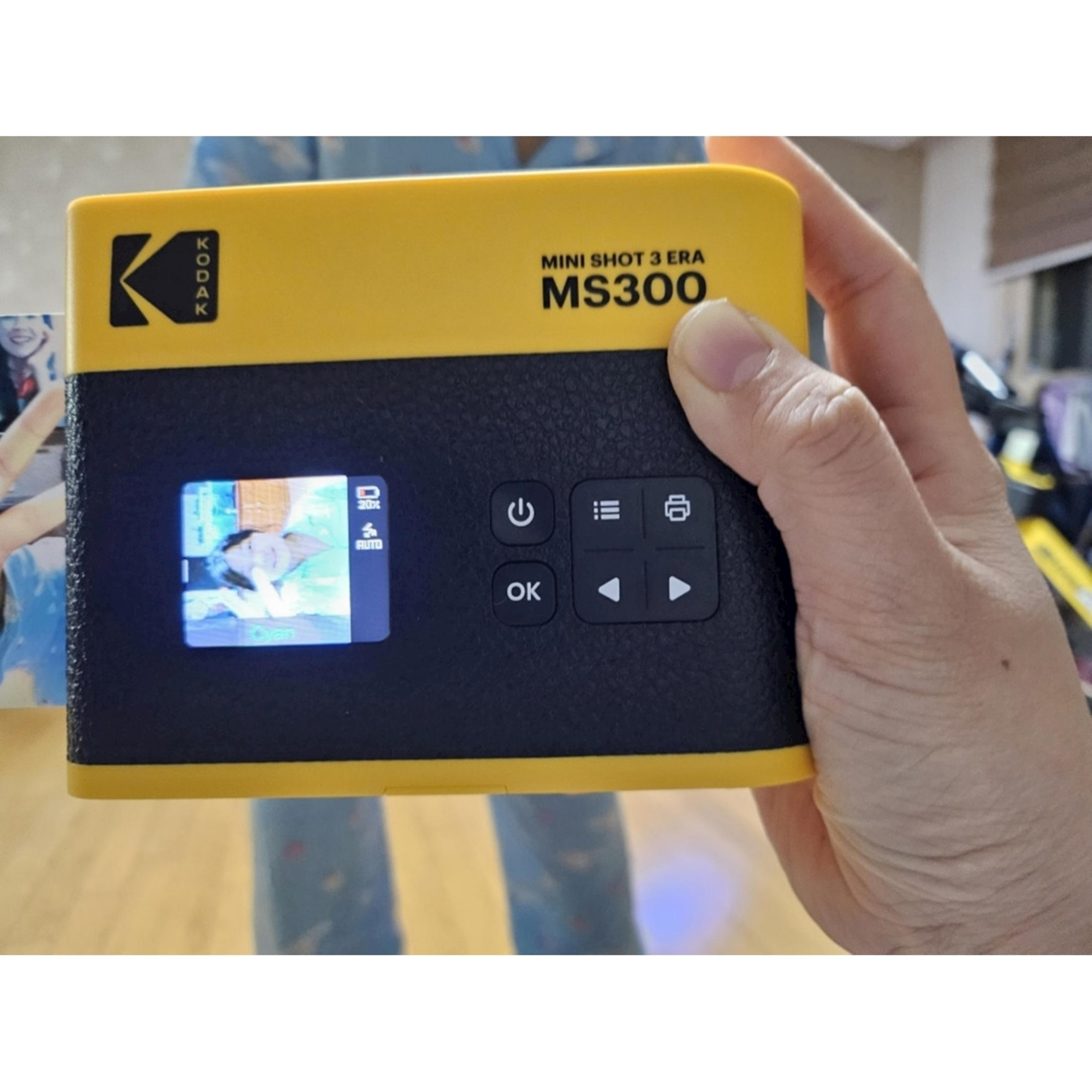 Una mano tiene una fotocamera Kodak Mini Shot 3 Era MS300 gialla con un'immagine sullo schermo.