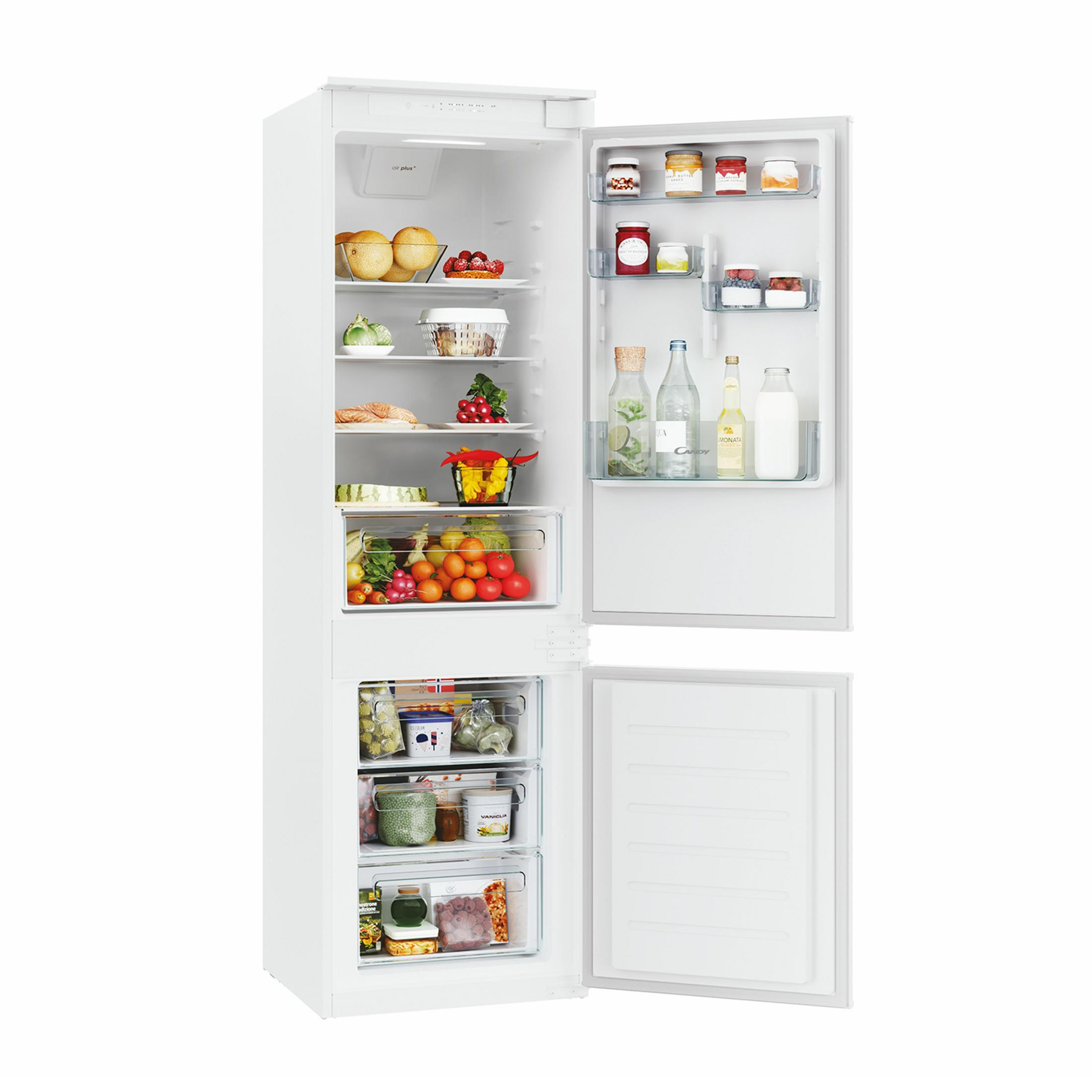 Un frigorifero bianco aperto pieno di cibo come frutta, verdura, marmellate e bevande.