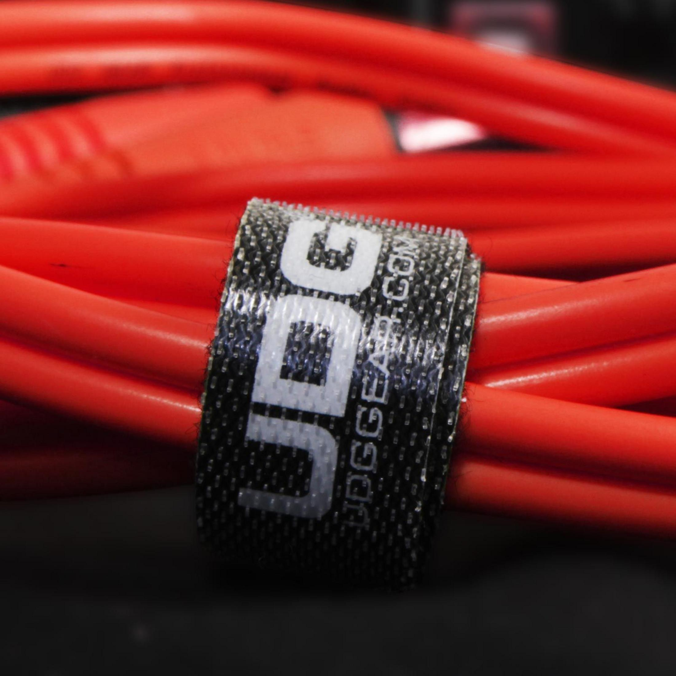 Rote Kabel, gebündelt mit einem Klettverschlussband mit dem UDG-Logo.