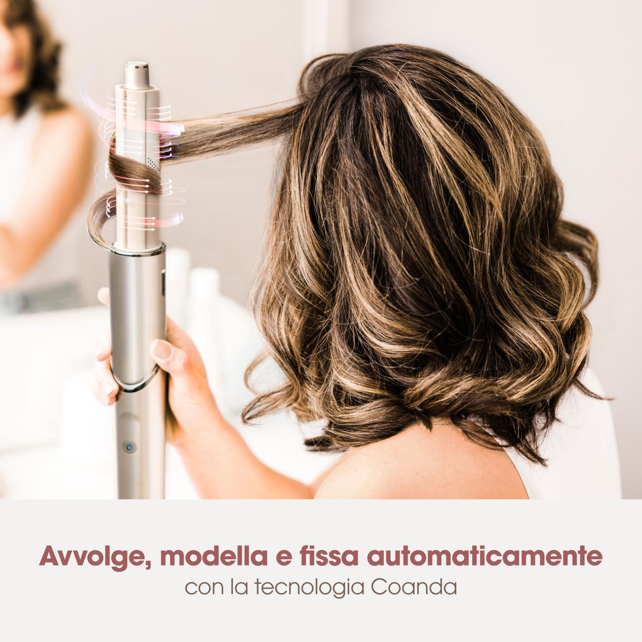 Una mano tiene un ferro arricciacapelli che modella automaticamente i capelli di una donna.