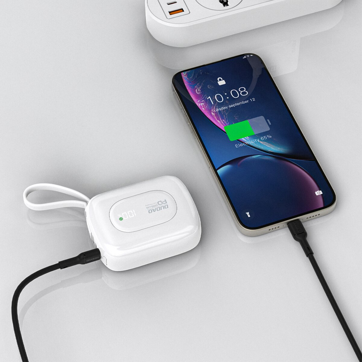 Ein weißer Ladeakku ist mit einem Smartphone verbunden, das aufgeladen wird.