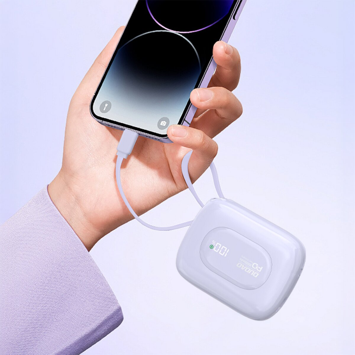 Eine Hand hält ein lila Smartphone, das mit einem weißen Ladekabel an eine weiße Powerbank angeschlossen ist.