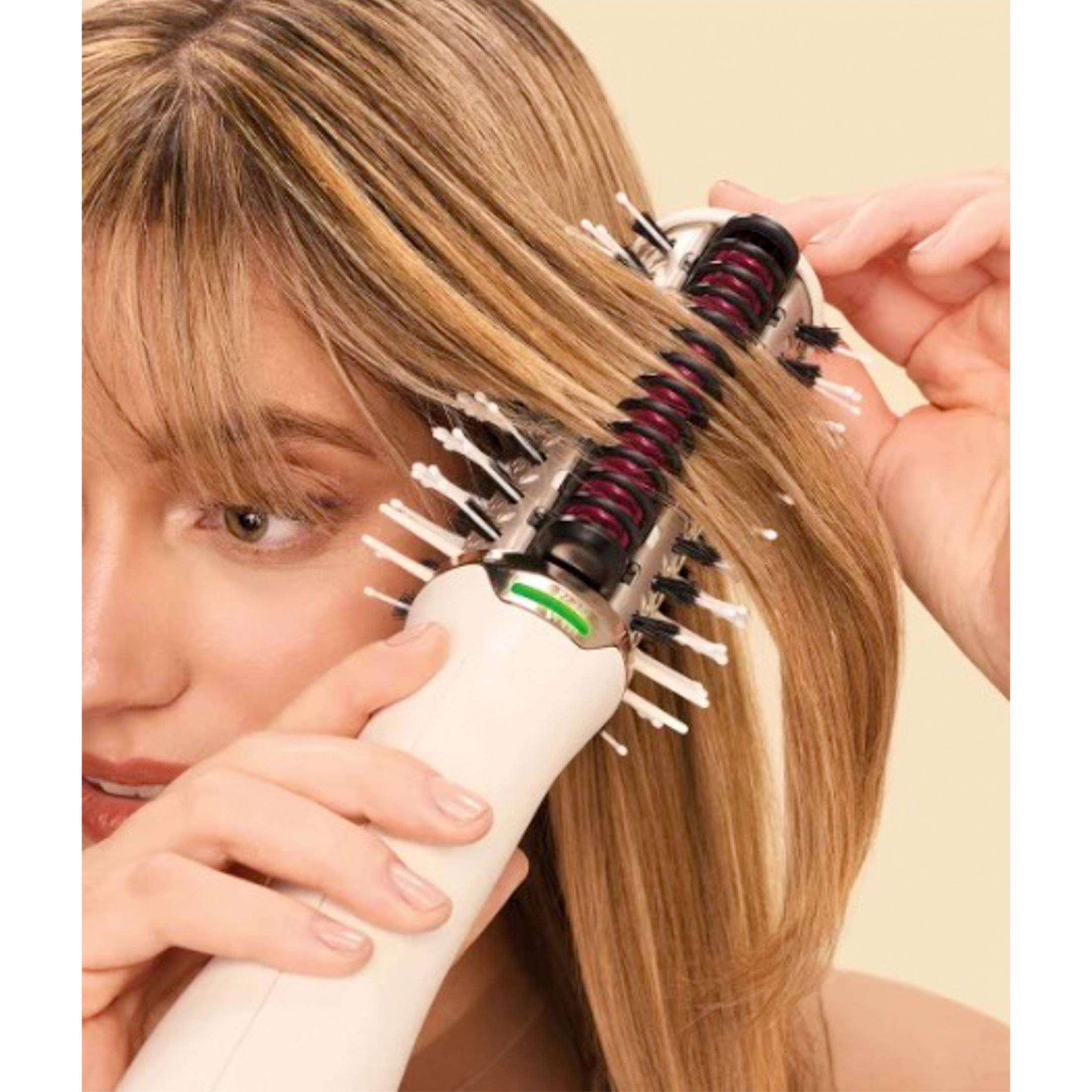 Kobieta stylizuje blond włosy kremową szczotką obrotową.