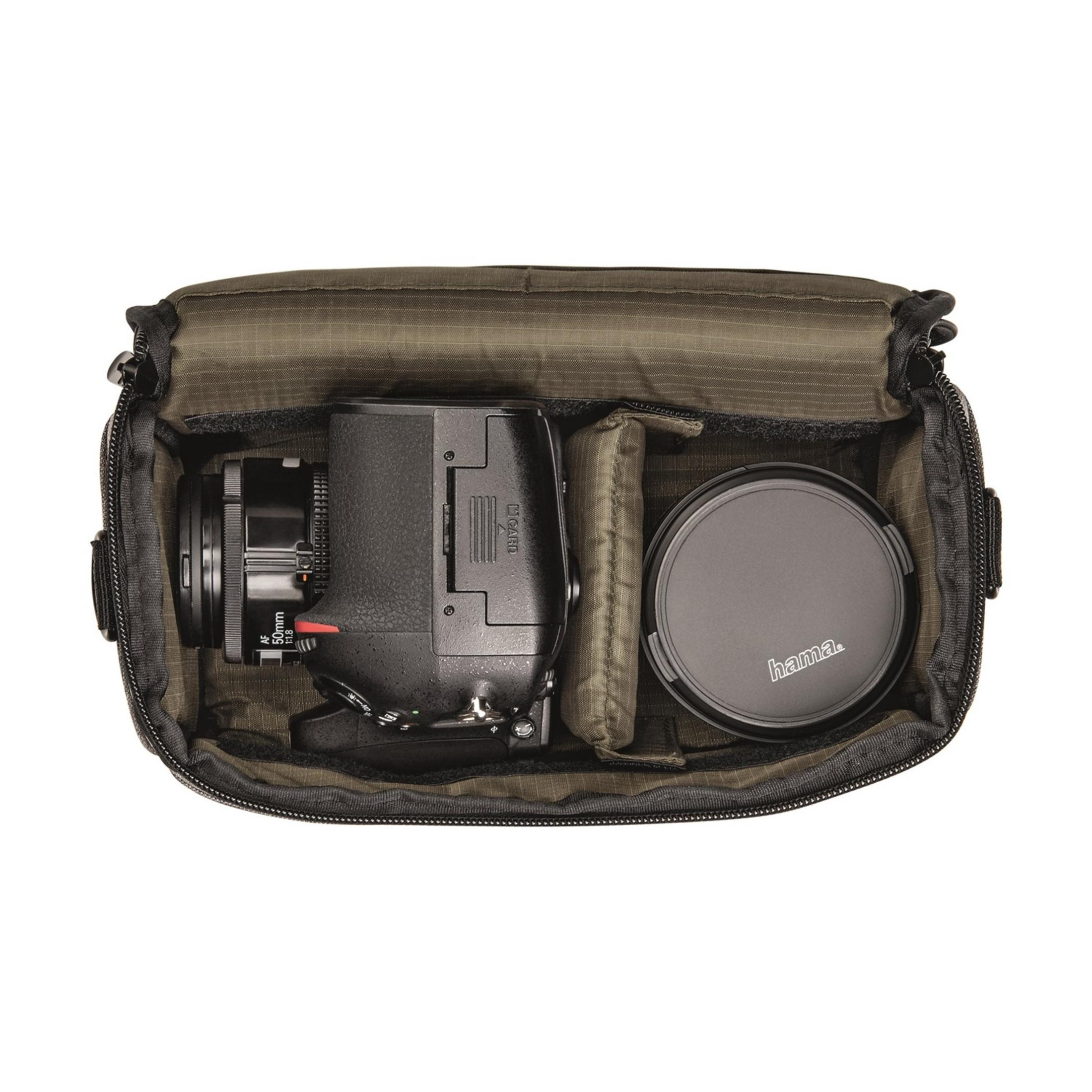 Eine Digitalkamera mit Objektiv und Objektivdeckel in einer offenen Tasche.
